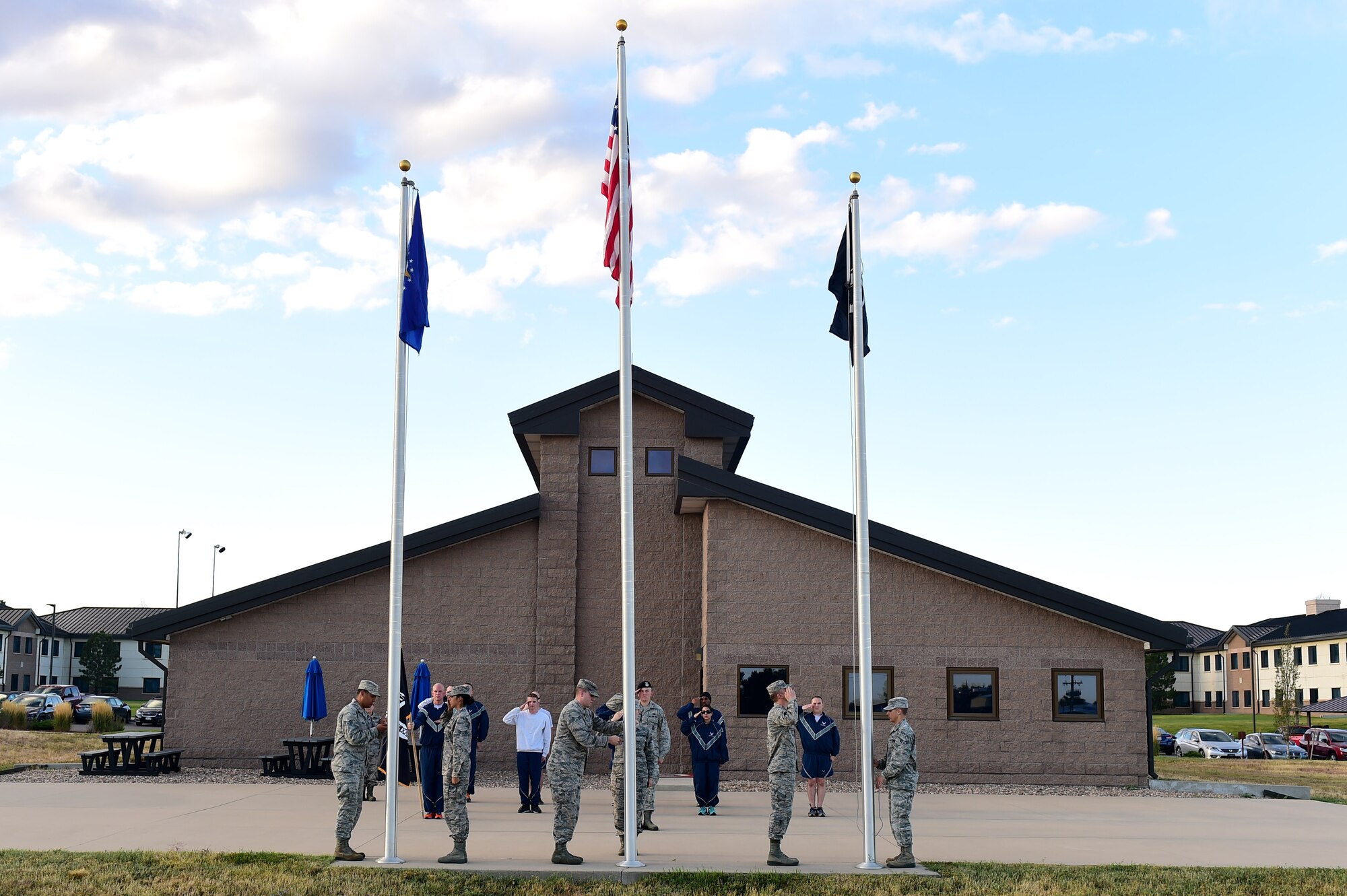 Team Buckley Airman Leadership School students salute as the flags are raised during a 24-hour POW/MIA memorial run Sept. 16, 2016, at an outdoor track on Buckley Air Force Base, Colo.  The run served as remembrance of those servicemen and women who never returned home. (U.S. Air Force photo by Airman 1st Class Gabrielle Spradling/Released)