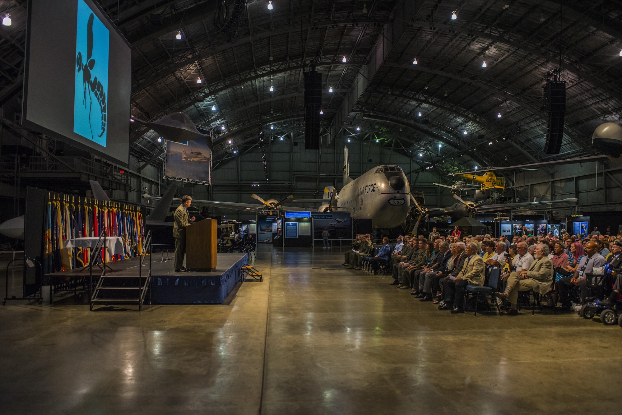 A crowd of military veterans, current military members, family and friends listen during the Green Hornet Dedication ceremony at the National Museum of the United States Air Force near Wright-Patterson Air Force Base, Ohio, Sept. 15, 2016. More than 300 people were in attendance of the ceremony which honored veterans of the 20th Special Operations Squadron with an exhibit and diorama depicting their rescue mission in Vietnam on Nov. 26, 1968. (U.S. Air Force photo by Senior Airman Luke Kitterman/Released)