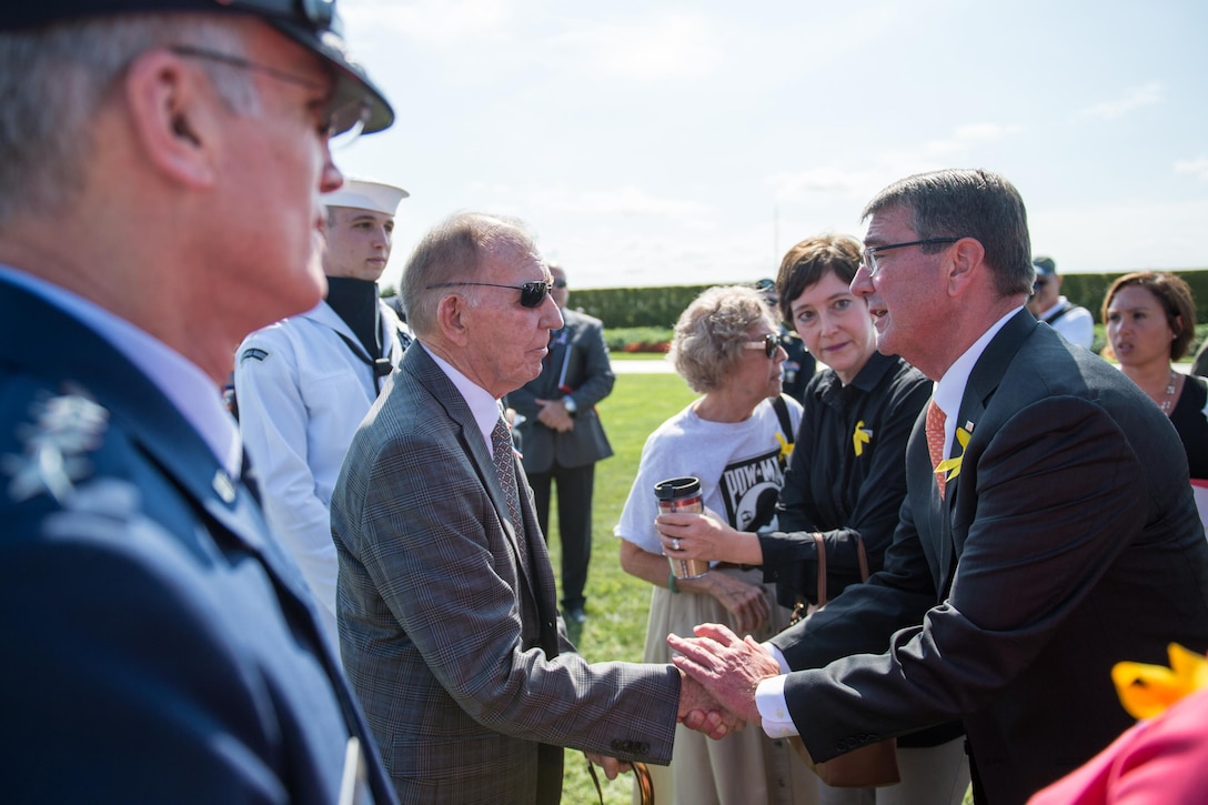 Defense Secretary Ash Carter shakes hands with retired Navy Capt. Gerald Coffee as Air Force Gen. Paul J. Selva, vice chairman of the Joint Chiefs of Staff, looks on after a ceremony commemorating National POW/MIA Recognition Day at the Pentagon, Sept. 16, 2016. Coffee spent seven years as a prisoner of war in Vietnam. DoD photo by Army Sgt. James K. McCann