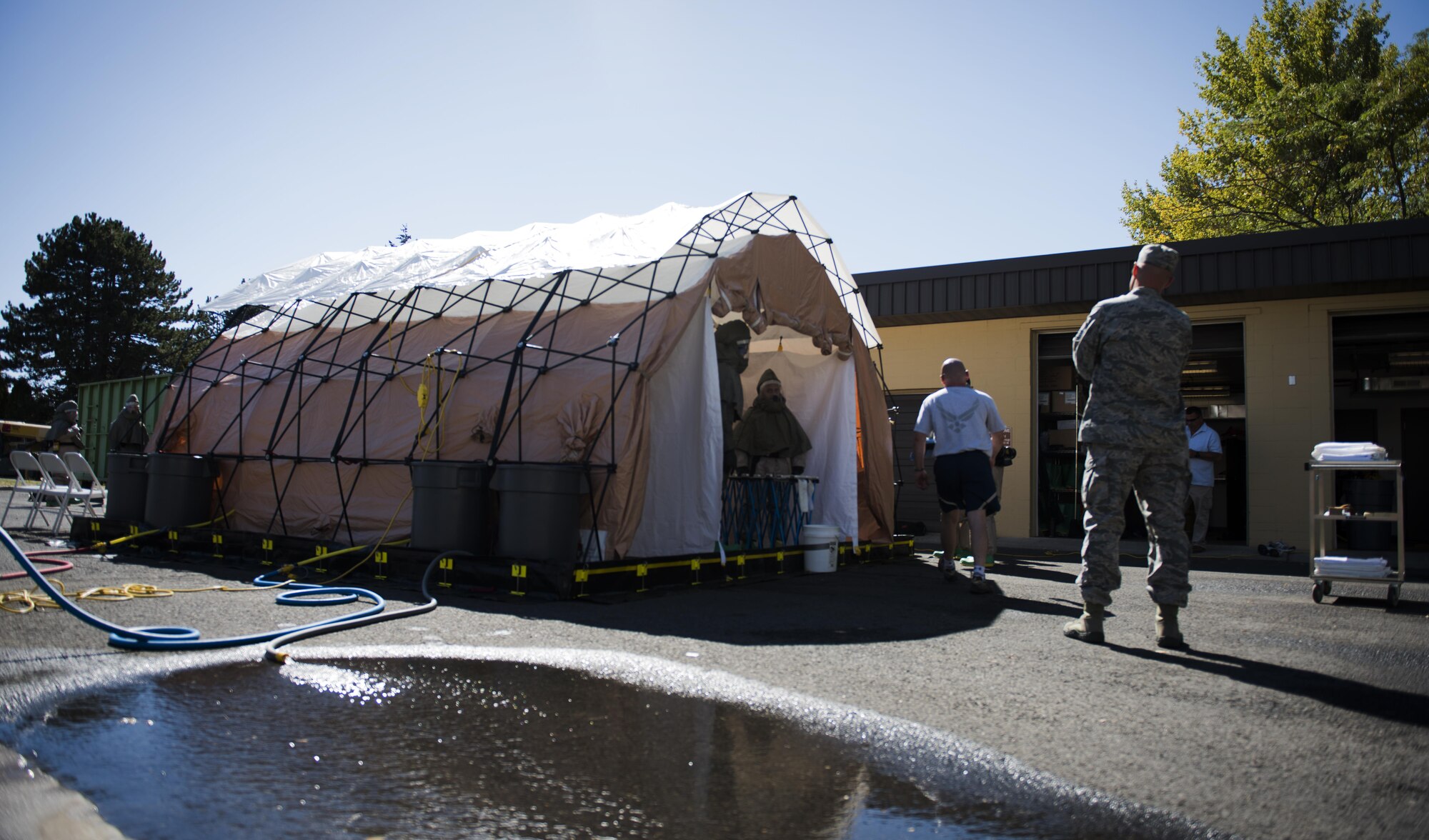Fairchild Airmen set up a decontamination tent during a mock decontamination training exercise Sept. 16, 2016, at Fairchild Air Force Base, Wash. The hands-on portion of the training is a full test of mission capability, which includes setting up the decontamination tent and having team members put on their protective suits in less than 15 minutes. (U.S. Air Force photo/Airman 1st Class Sean Campbell)