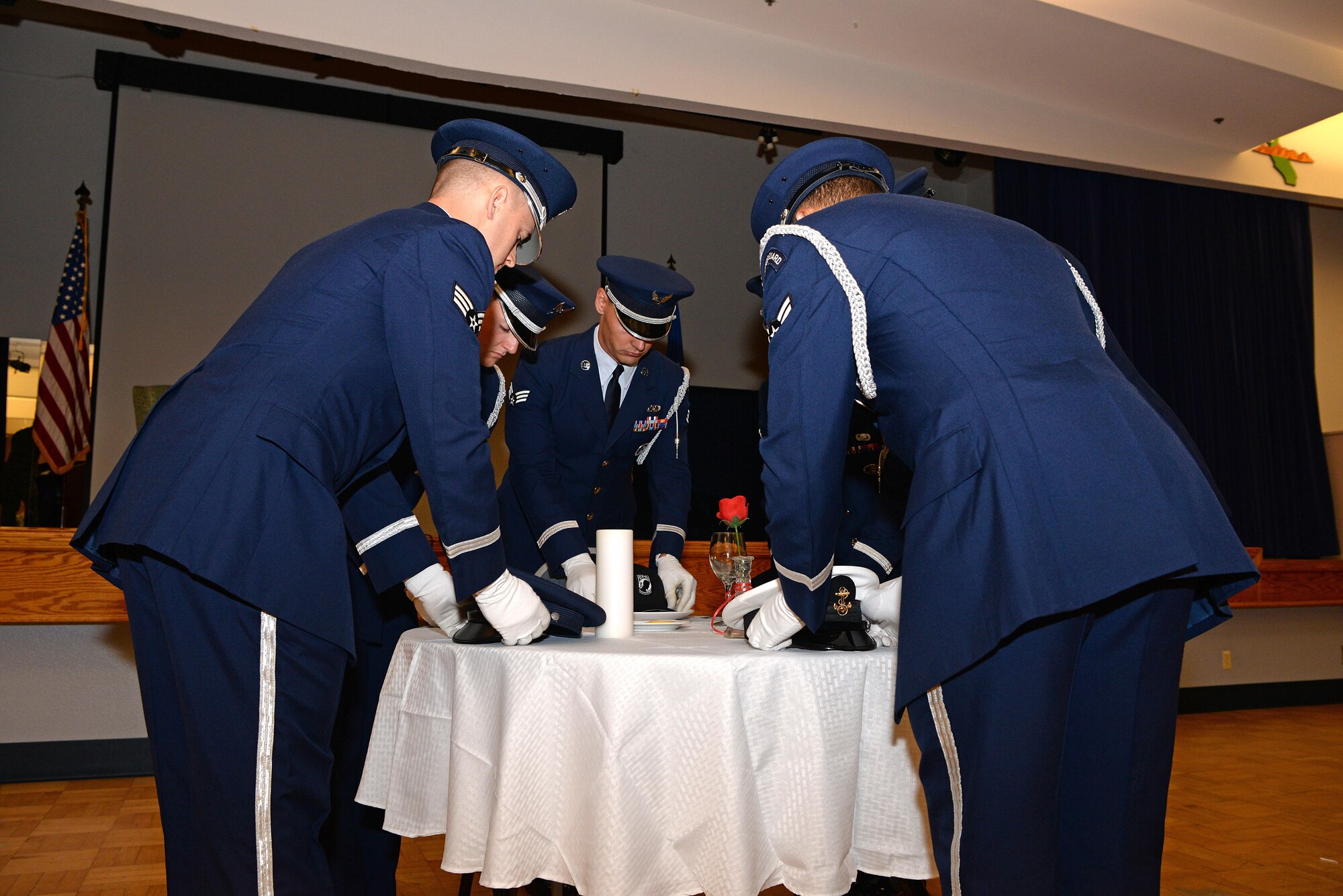 The Beale Air Force Base Honor Guard places the service covers of all the branches of the military on a table to honor the service members who were prisoners of war or those who remain missing in action at the POW/MIA ceremonial breakfast Sept. 15, 2016, at Beale Air Force Base, California. More than 82,000 American service members are still considered missing in action. (U.S. Air Force photo/Airman Tristan D. Viglianco)