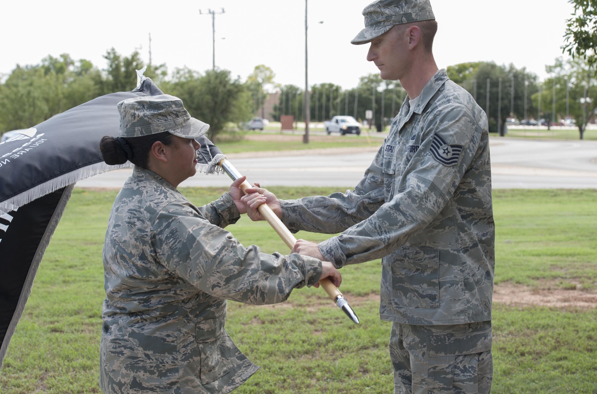 U.S. Air Force Maj. Christina Encina, 7th Medical Support Squadron diagnostics flight commander, hands over the prisoner of war/missing in action flag to Tech. Sgt. David Stai, 7th Aircraft Maintenance Squadraon B-1B Lancer production expeditor, at Dyess Air Force Base, Sept. 16, 2016. The POW/MIA flag was designed during the Vietnam war and carries no trademark nor copyright to allow for nonrestrictive, widespread use. (U.S. Air Force photo by Airman 1st Class Rebecca Van Syoc)