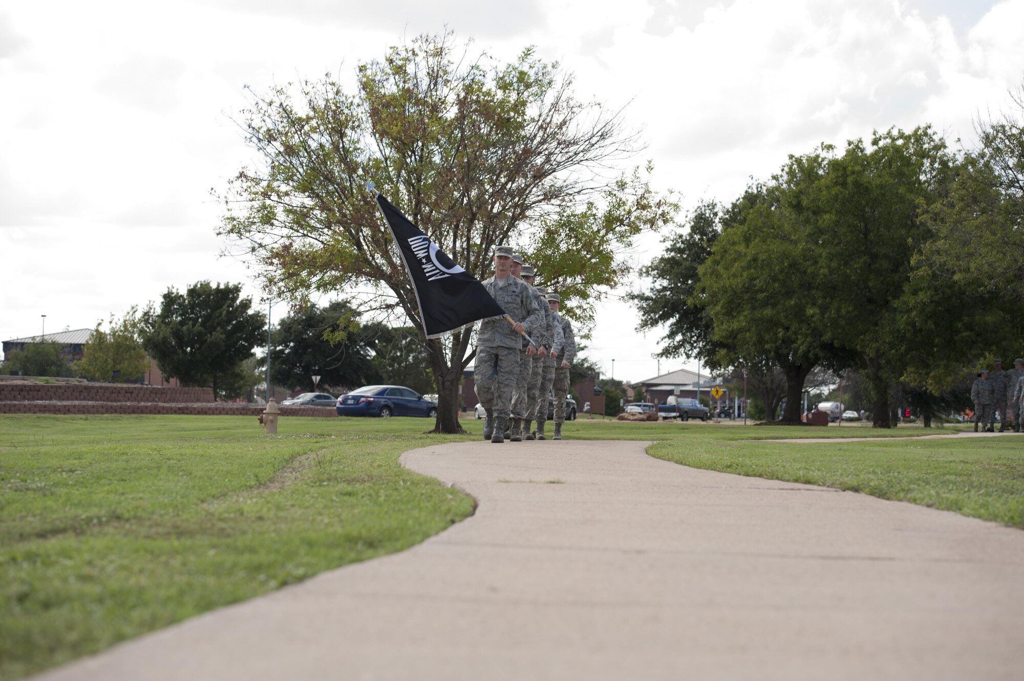 U.S. Air Force Airmen carry the prisoner-of-war/missing-in-action flag as part of the national POW/MIA recognition day, at Dyess Air Force Base, Texas, Sept. 16, 2016. Formations of five Airmen marched from one end to the other of the installation’s linear air park while displaying the POW/MIA flag in order to honor past service members lost and missing. (U.S. Air Force photo by Airman 1st Class Rebecca Van Syoc)
