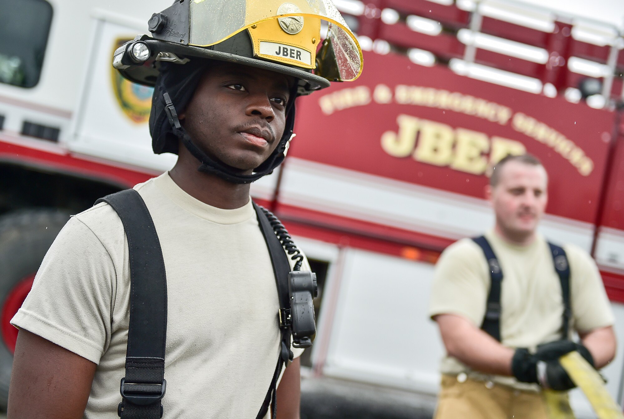 Fire protection specialist Airman 1st Class Brian Charles, a native of Ft. Lauderdale, Fla., assigned to the 673rd Civil Engineer Squadron, watches fellow Airmen gather water hoses after firefighter training on a simulated aircraft fire at Joint Base Elmendorf-Richardson, Alaska, Wednesday, Sept. 14, 2016.  Aircraft live fire training is conducted periodically throughout the year at JBER to ensure Airmen are prepared to combat aircraft fuel fires.