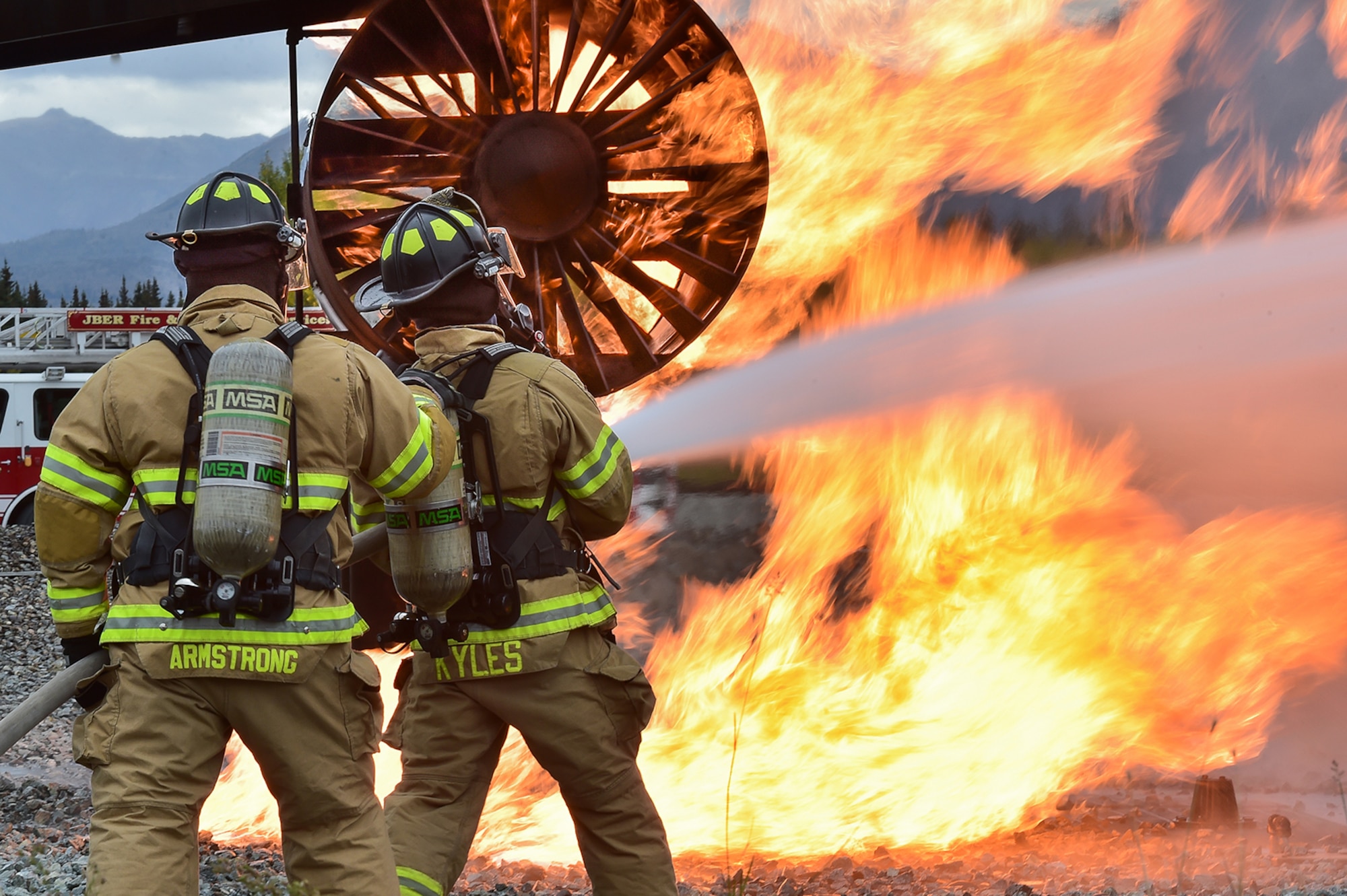 Fire protection specialists Tech Sgt. Sean Armstrong, left, and Senior Airman Larry Kyles, assigned to the 673rd Civil Engineer Squadron, perform firefighter training on a simulated aircraft fire at Joint Base Elmendorf-Richardson, Alaska, Wednesday, Sept. 14, 2016.  Aircraft live fire training is conducted periodically throughout the year at JBER to ensure Airmen are prepared to combat aircraft fuel fires. 