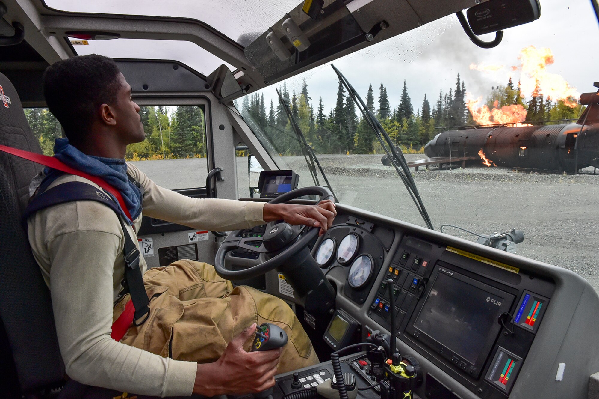 Fire protection specialist Senior Airman Larry Kyles, a native of Dallas, Texas, assigned to the 673rd Civil Engineer Squadron, drives a Striker vehicle during firefighter training on a simulated aircraft fire at Joint Base Elmendorf-Richardson, Alaska, Wednesday, Sept. 14, 2016.  Aircraft live fire training is conducted periodically throughout the year at JBER to ensure Airmen are prepared to combat aircraft fuel fires.