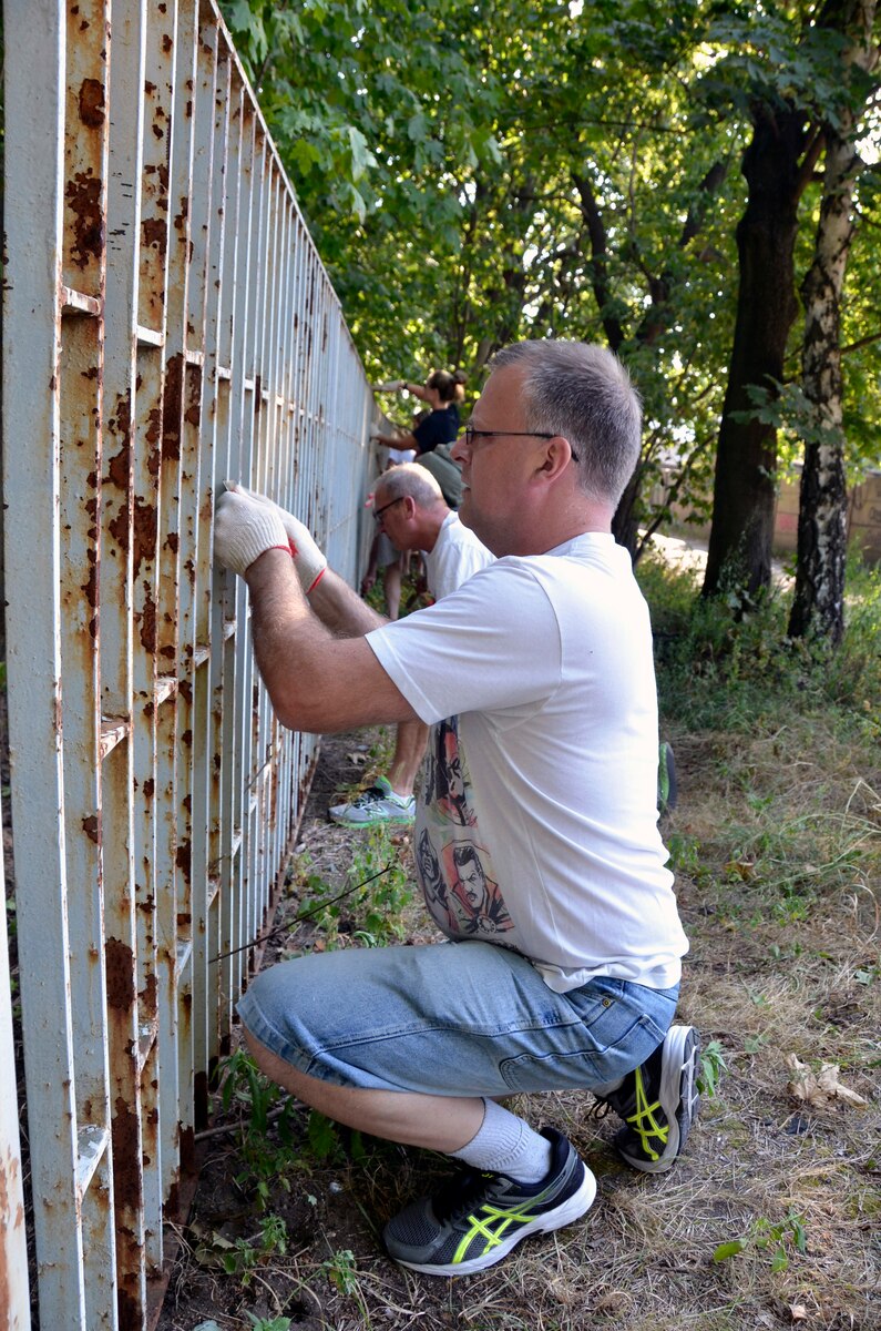 Master Sgt. Aaron Levisay scrapes and prepares a fence for painting at the Botanical Gardens in Lodz, Poland, Sept. 13, 2016. The 114 FW deployed more than 100 personnel to support Aviation Detachment 16-4, a bilateral training exercise between the U.S. and Polish forces. Levisay is the 114th Fighter Wing Financial Management Services non-commissioned officer in charge   . The unit sought out the volunteer opportunity as a way to give back to the local community. (U.S. Air National Guard photo by Capt. Amy Rittberger)