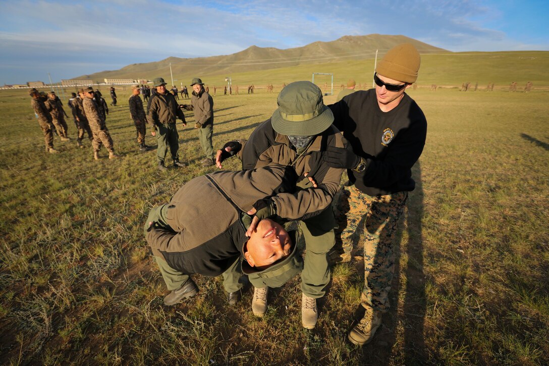 U.S. Marine 1st Lt. Michael McDonald helps a Mongolian Armed Forces soldier adjust his mechanical advantage control holds techniques during Non-Lethal Executive Seminar (NOLES) 2016 at the Five Hills Training Area, Mongolia, Sept. 16, 2016. McDonald is the officer in charge of the Marines participating in NOLES. Mongolian soldiers and police learned mechanical advantage control holds techniques as an additional non-lethal option when apprehending suspects. NOLES is a regularly scheduled field training exercise and leadership seminar hosted annually by various nations throughout Asia Pacific. 