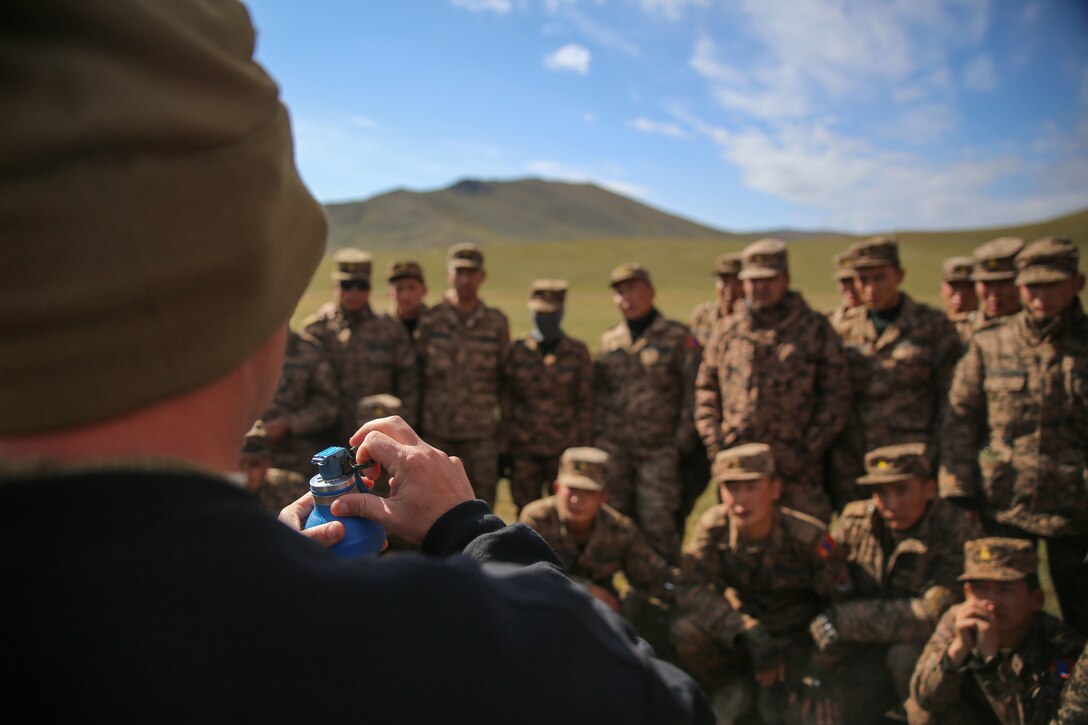 U.S. Marine Staff Sgt. Joseph Ross instructs the Mongolian Armed Forces soldiers and the Mongolian National Police on the proper procedures for handling a grenade during Non-Lethal Executive Seminar (NOLES) 2016 at Five Hills Training Area, Mongolia, Sept. 15, 2016. Ross is a platoon sergeant with 1st Platoon, A Company, 3rd Law Enforcement Battalion, III Marine Expeditionary Force. Mongolian police and soldiers fired non-lethal munitions from a M203 grenade launcher, Mossberg 500A2 shotgun, and M32 grenade launcher. NOLES is a regularly scheduled field training exercise and leadership seminar hosted annually by various nations throughout Asia Pacific.