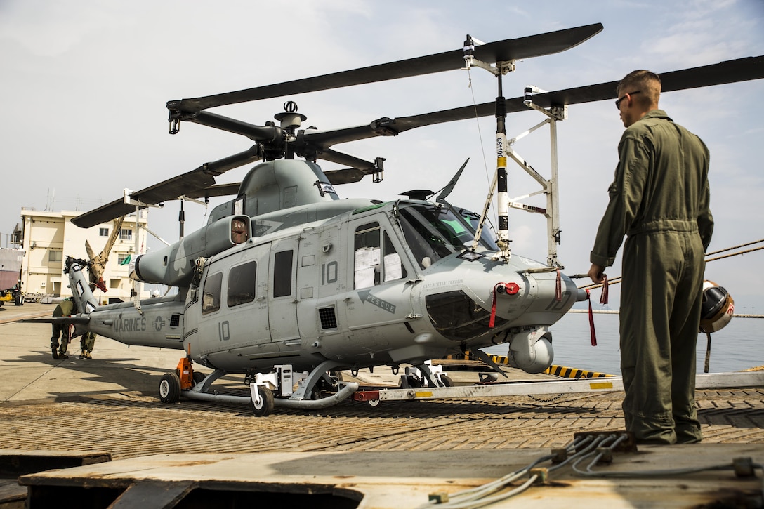 U.S. Marines with Marine Light Attack Helicopter Squadron (HMLA) 469, unload a UH-1Y Venom at Marine Corps Air Station Iwakuni, Japan, Sept. 16, 2016. Three UH-1Y Venoms, two MV-22C Ospreys and one CH-53E Super Stallion, and are scheduled to fly to their destination in Okinawa after concluding preparations at MCAS Iwakuni. The Green Cove, a vehicle carrier, transported the aircraft approximately 6,000 miles from Naval Air Station North Island, San Diego, Calif. Delivering aircraft by boat is more cost effective than flying from the U.S. to Japan, and MCAS Iwakuni has both airport and seaport capabilities, which no other Marine Corps installation has. (U.S. Marine Corps photo by Lance Cpl. Aaron Henson)