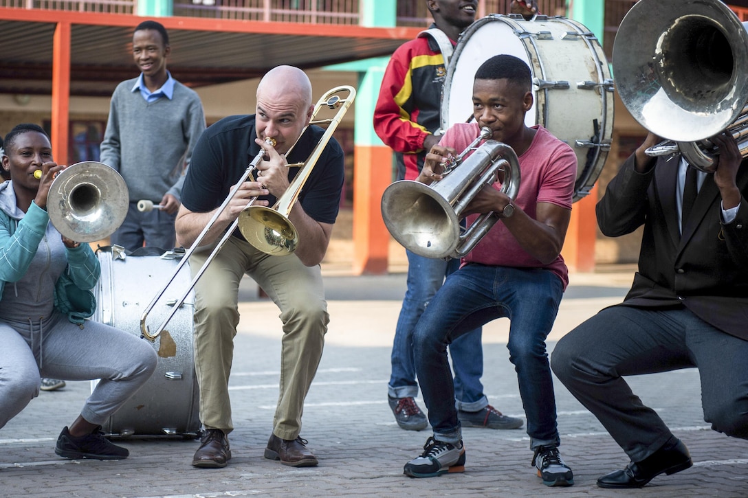 Air Force Staff Sgt. Ben Huseby, center left, plays trombone with a music school band in Johannesburg, Sept. 15, 2016. Huseby is with the Air Forces in Europe Band, which traveled to South Africa for the week to perform at the Africa Aerospace and Defense expo. Air Force photo by Tech. Sgt. Ryan Crane
