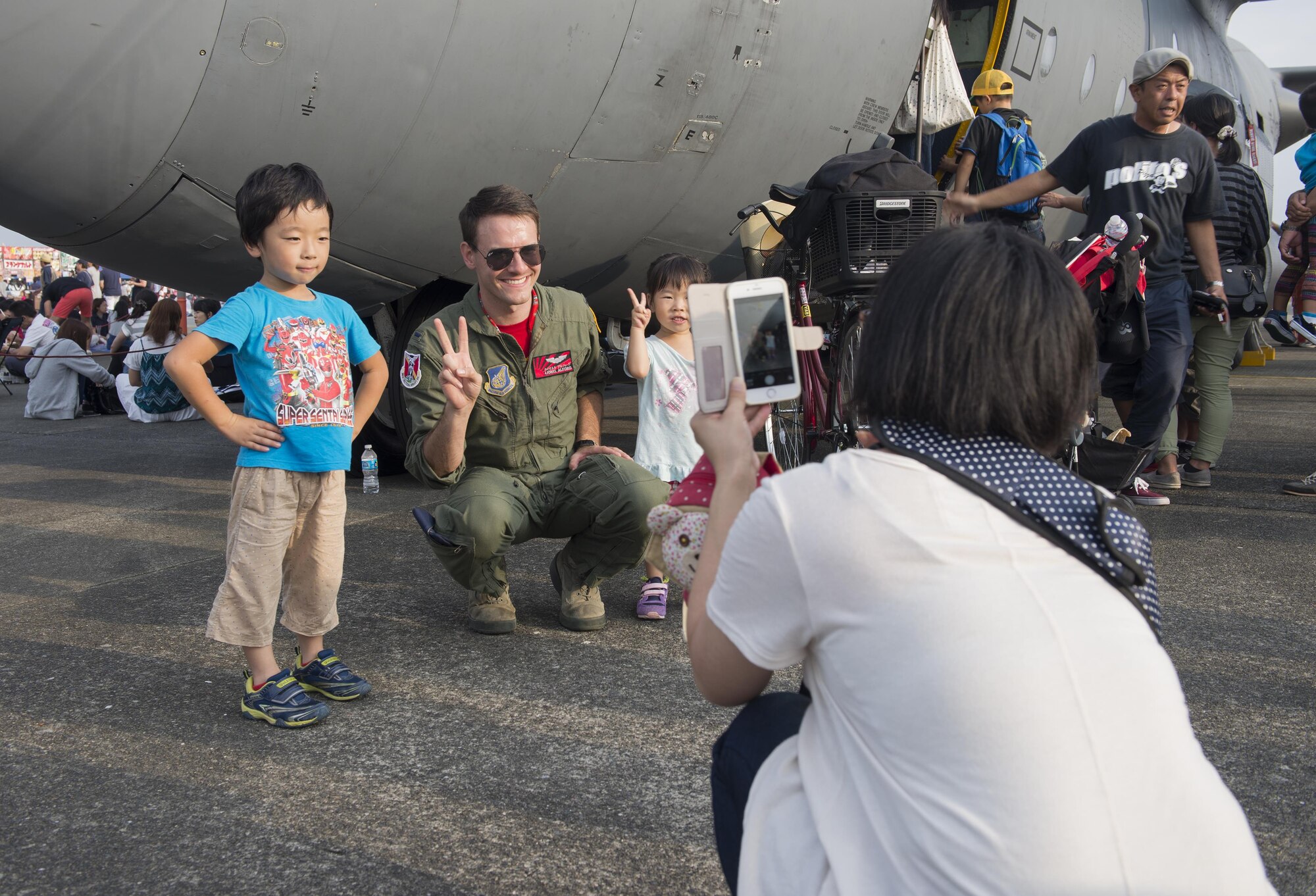 1st Lt. Lionel Alford, 36th Airlift Squadron C-130 Hercules pilot, poses for photos with Friendship Festival attendees at Yokota Air Base, Japan, Sept. 17, 2016. The event also included live band performances, a strongman competition, aerial and static displays and a military working dog demonstration. (U.S. Air Force photo by Senior Airman David C. Danford/Released)