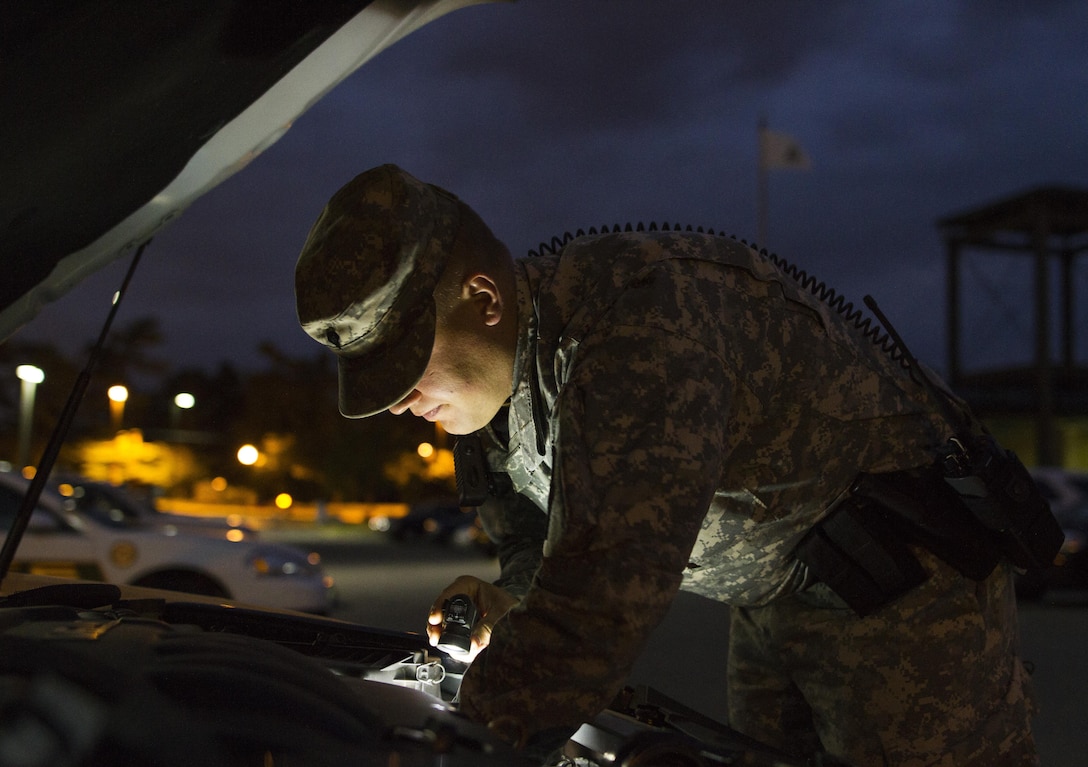 Spc. Bradley A. Skowronski, a U.S. Army Reserve military police Soldier assigned to the 102nd MP Company out of Sheboygan, Wisc., conducts preventive maintenance checks and services on his assigned vehicle before beginning watch on Fort Meade, Md., Sept. 16. Skowronski is part of a group of Soldiers participating in   the ongoing partnership between the 200th Military Police Command and the Military District of Washington.  Through this partnership, the military police Soldiers not only receive law enforcement certification, they also get real-world experience. (U.S. Army Reserve photo by Spc. Stephanie Ramirez) 