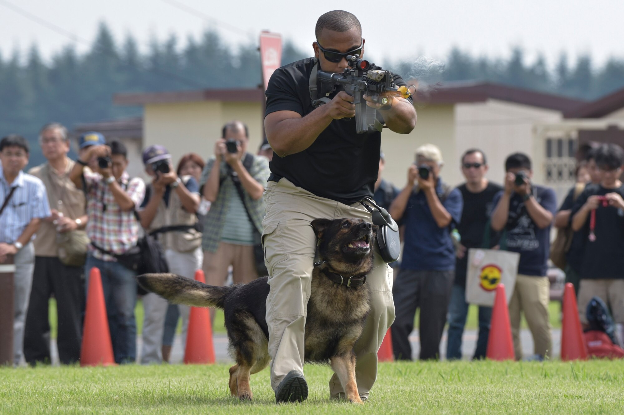 Staff Sgt. Dontae Stamps, 374th Security Forces Squadron military working dog handler, fires simulated rounds during the 2016 Friendship Festival K-9 demonstration at Yokota Air Base, Japan, Sept. 17, 2016. The festival hosted food vendors, static aircraft displays, live entertainment and military and government demonstrations. (U.S. Air Force photo by Machiko Imai/Released)