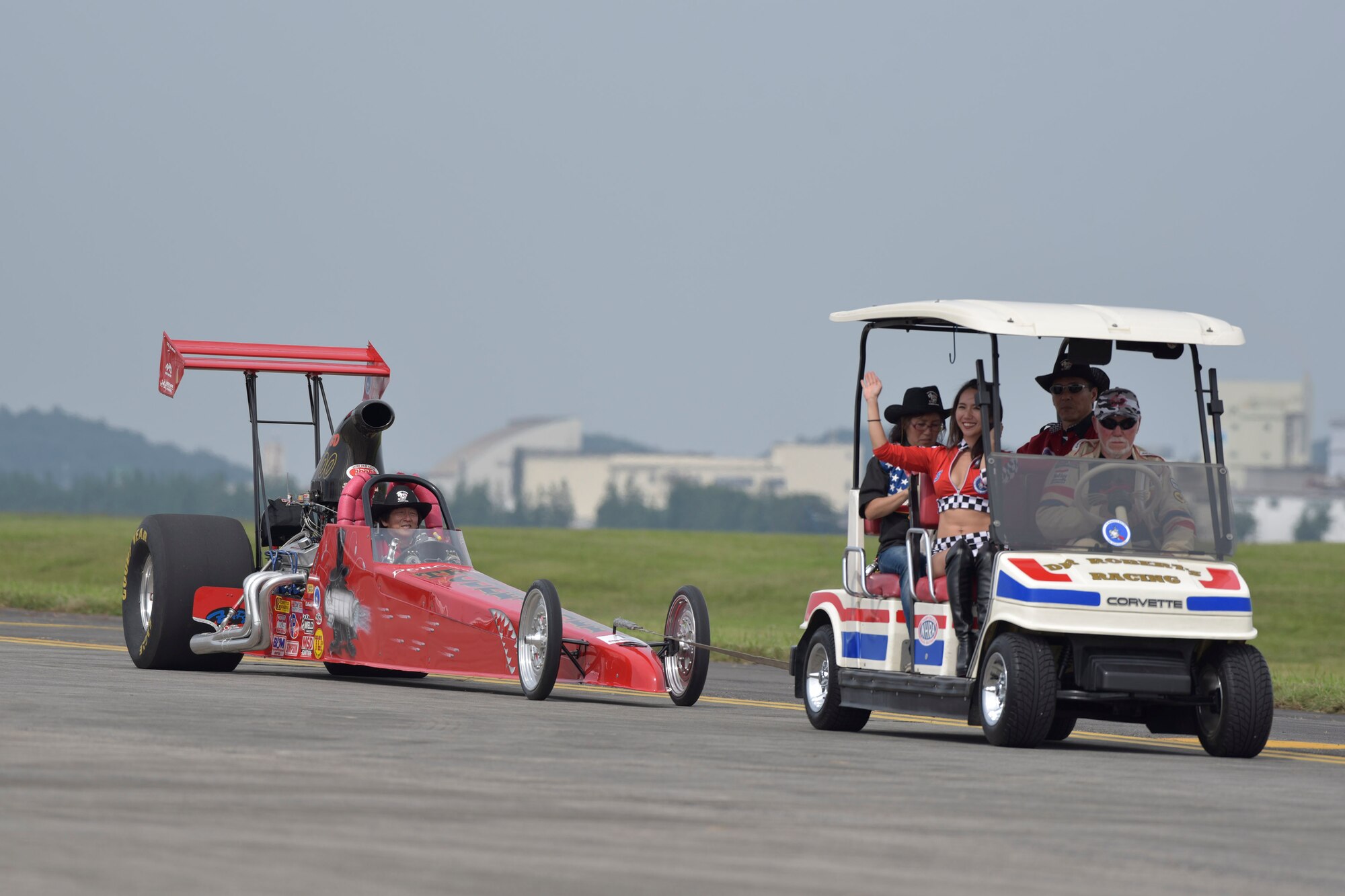 Drag racing car performers wave to audience members during the 2016 Friendship Festival at Yokota Air Base, Japan, Sept. 17, 2016. In 2015, more than 185,000 people attended the two-day festival (U.S. Air Force photo by Machiko Imai/Released)