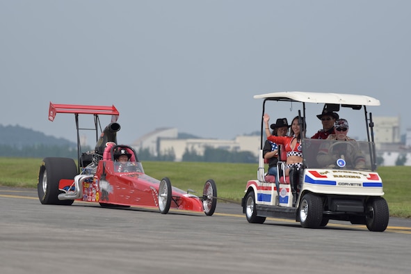 Drag racing car performers wave to audience members during the 2016 Friendship Festival at Yokota Air Base, Japan, Sept. 17, 2016. In 2015, more than 185,000 people attended the two-day festival (U.S. Air Force photo by Machiko Imai/Released)