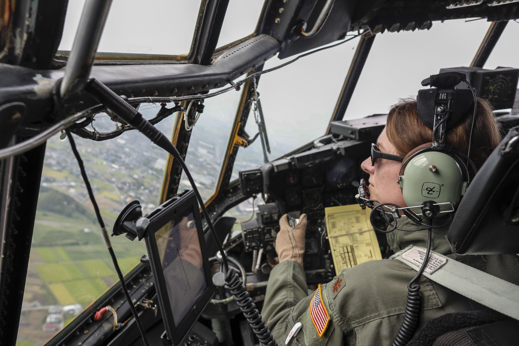 Maj. Dominique Haig, 36th Airlift Squadron chief of standardization and evaluation evaluator C-130H pilot, flies over the Kanto plains, Japan, during the 2016 Friendship Festival, Sept. 17, 2016. The 36th Airlift Squadron demonstrated their airdrop capabilities to a crowd of tens of thousands. (U.S. Air Force photo by Yasuo Osakabe/Released) 