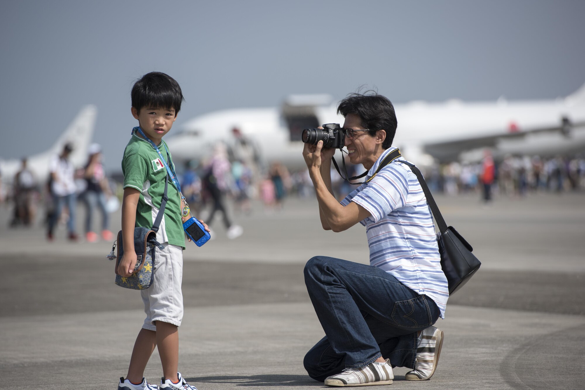 A man photographs his son in front of an aircraft at the 2016 Japanese-American Friendship Festival at Yokota Air Base, Japan, Sept. 17, 2016. The festival is held annually at Yokota; more than 185,000 festivalgoers attended in 2015. (U.S. Air Force photo by Staff Sgt. Cody H. Ramirez/Released)