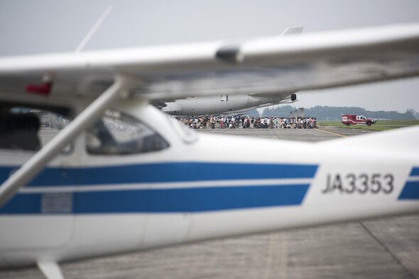 Hundreds of people crowd to see a drag car demonstration during the 2016 Japanese-American Friendship Festival at Yokota Air Base, Japan, Sept. 17, 2016. The drag car sped down the flightline, showcasing their speed for the festivalgoers. (U.S. Air Force photo by Staff Sgt. Cody H. Ramirez/Released)