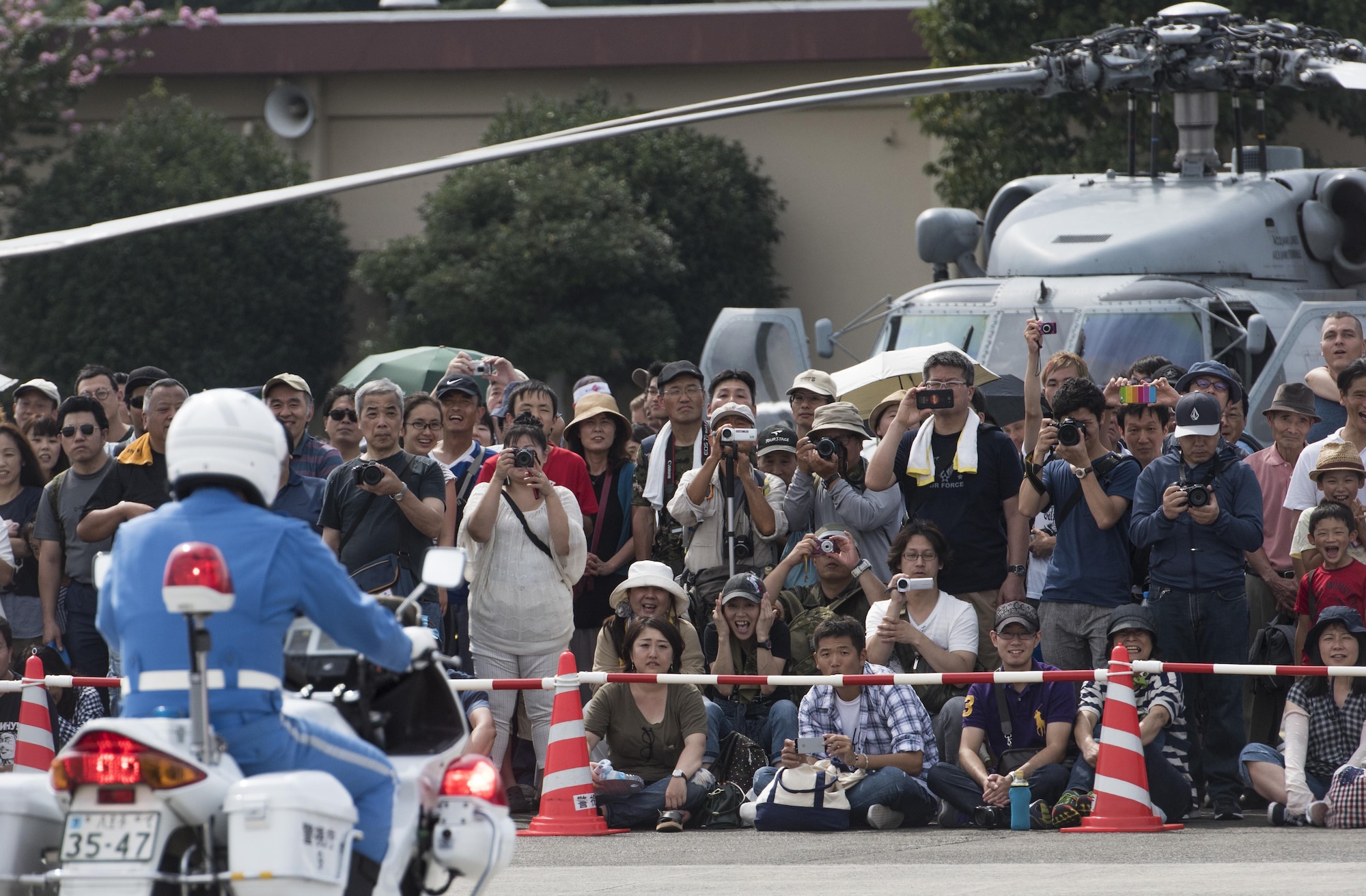 A crowd watches the Tokyo Metropolitan Police Department 9th District traffic mobile unit conduct their motorcycle demonstration during the 2016 Japanese-American Friendship Festival at Yokota Air Base, Japan, Sept. 17, 2016. The festival hosted food vendors, static aircraft displays, live entertainment and military and government demonstrations. (U.S. Air Force photo by Staff Sgt. Cody H. Ramirez/Released)
