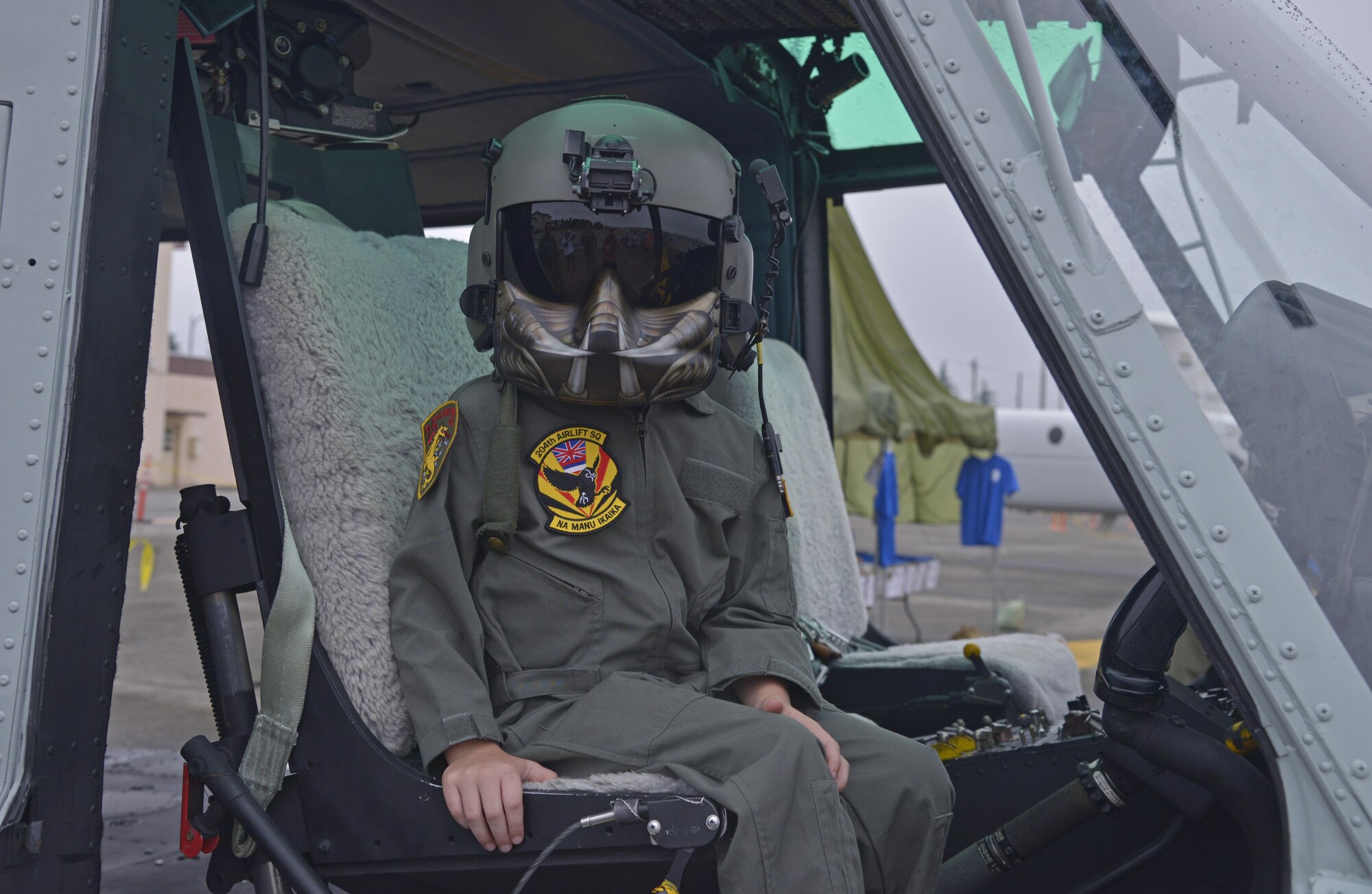 Gage Richardson, 7, son of Col. Niel Richardson, 374th Airlift Wing vice commander, sits inside of a UH-1N Iriquois while wearing a helmet and mask during the Friendship Festival at Yokota Air Base, Japan, Sept. 18, 2016. The festival allowed visitors to interact with aircrew and receive a first hand view of what it's like inside of Japan Air Self-Defense Force and American aircraft. (U.S. Air Force photo by Senior Airman David Owsianka/Released)