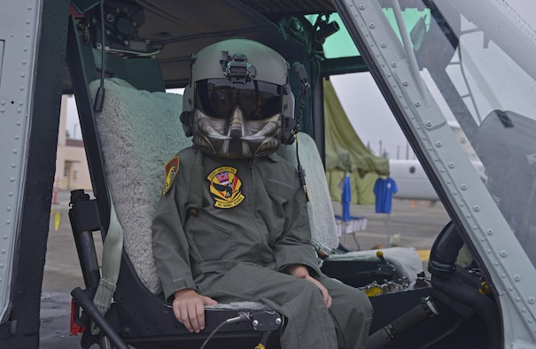 Gage Richardson, 7, son of Col. Niel Richardson, 374th Airlift Wing vice commander, sits inside of a UH-1N Iriquois while wearing a helmet and mask during the Friendship Festival at Yokota Air Base, Japan, Sept. 18, 2016. The festival allowed visitors to interact with aircrew and receive a first hand view of what it's like inside of Japan Air Self-Defense Force and American aircraft. (U.S. Air Force photo by Senior Airman David Owsianka/Released)