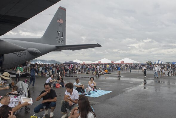 2016 Friendship Festival attendees queue up to tour the inside of a C-130 Hercules static display at Yokota Air Base, Japan, Sept. 18, 2016. The event also included live band performances, a strongman competition, aerial and static displays and a military working dog demonstration. (U.S. Air Force photo by Senior Airman David C. Danford/Released)