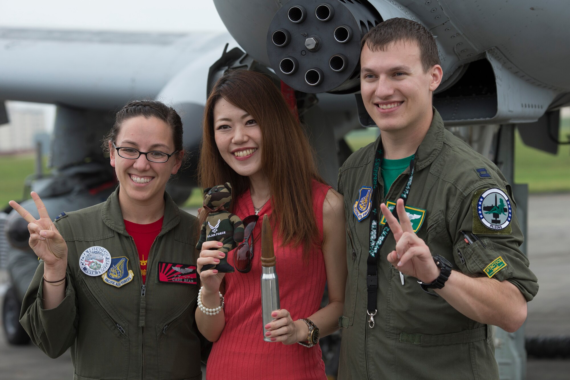 (Right to left) Capt. Travis Vayda, 25th Fighter Squadron A-10 pilot, and Capt. Sydney Croxton, 36th Airlift Squadron C-130 Hercules pilot, pose for a photo with a Japanese festivalgoer during the 2016 Friendship Festival at Yokota Air Base, Japan, Sept. 18, 2016. (U.S. Air Force photo by Yasuo Osakabe/Released)