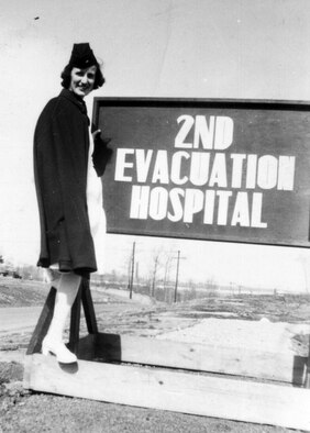 Anne Rissman poses in front of a sign of one of the hospitals she worked at during World War II. She made the journey across the Atlantic Ocean aboard the Queen Mary along with 5,000 other personnel to support the United States during WWII. (Courtesy Photo)