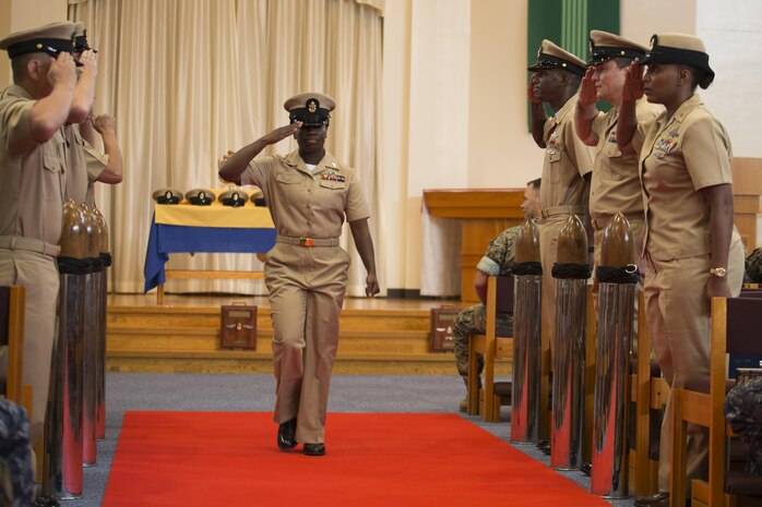 U.S. Navy Chief Petty Officer Lamonica Harrison, chief hospital corpsman with MCAS Iwakuni’s base health clinic, salutes her peers as she walks down the red carpet during a promotion ceremony in the Marine Memorial Chapel at Marine Corps Air Station Iwakuni, Japan, Sept. 16, 2016. Harrison said being in front of her peers and receiving the honor of chief petty officer filled her with pride and joy. (U.S. Marine Corps photo by Lance Cpl. Joseph Abrego)