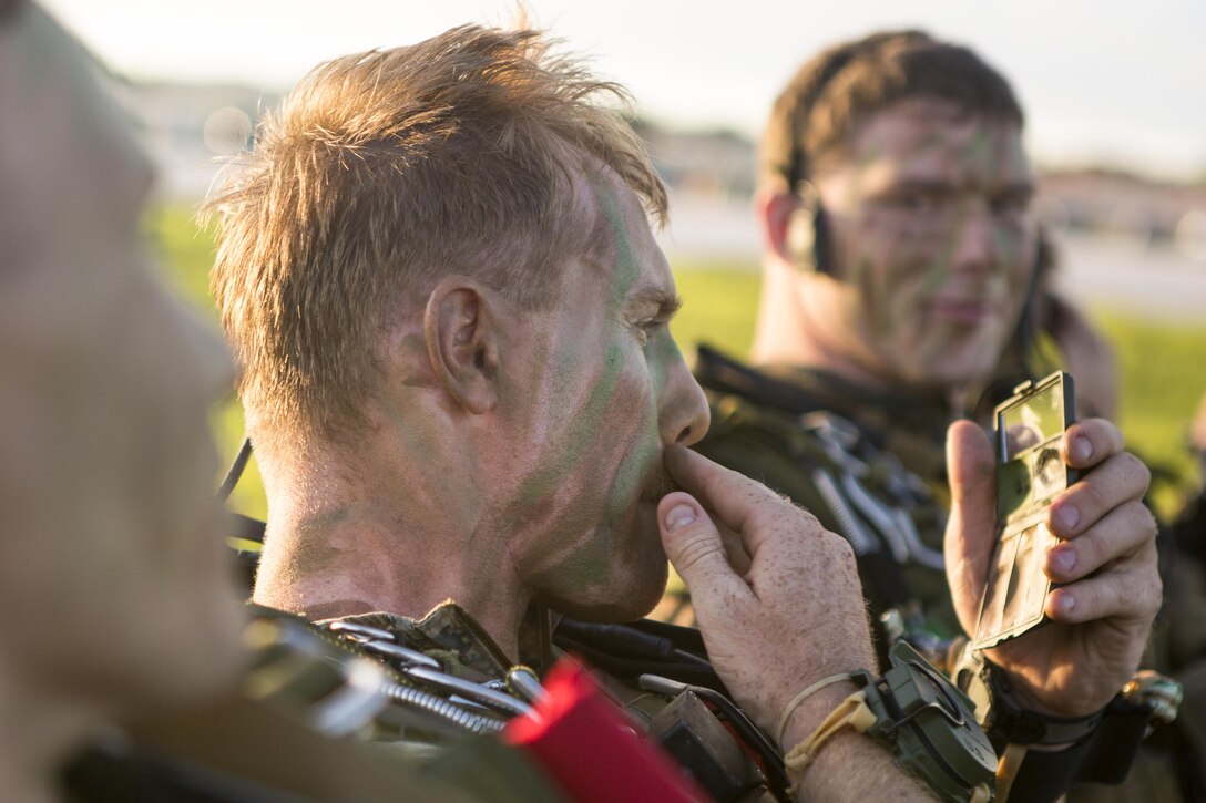 Marines apply camouflage paint before a high-altitude, low-opening, or HALO, jump for training exercise Valiant Shield on Andersen Air Force Base, Guam, Sept. 17, 2016. A HALO jump involves jumping from a high altitude and opening a parachute at a low altitude. Valiant Shield is a biennial, U.S. only field-training exercise with a focus on integration of joint training among U.S. forces. Marine Corps photo by Sgt. Justin Fisher