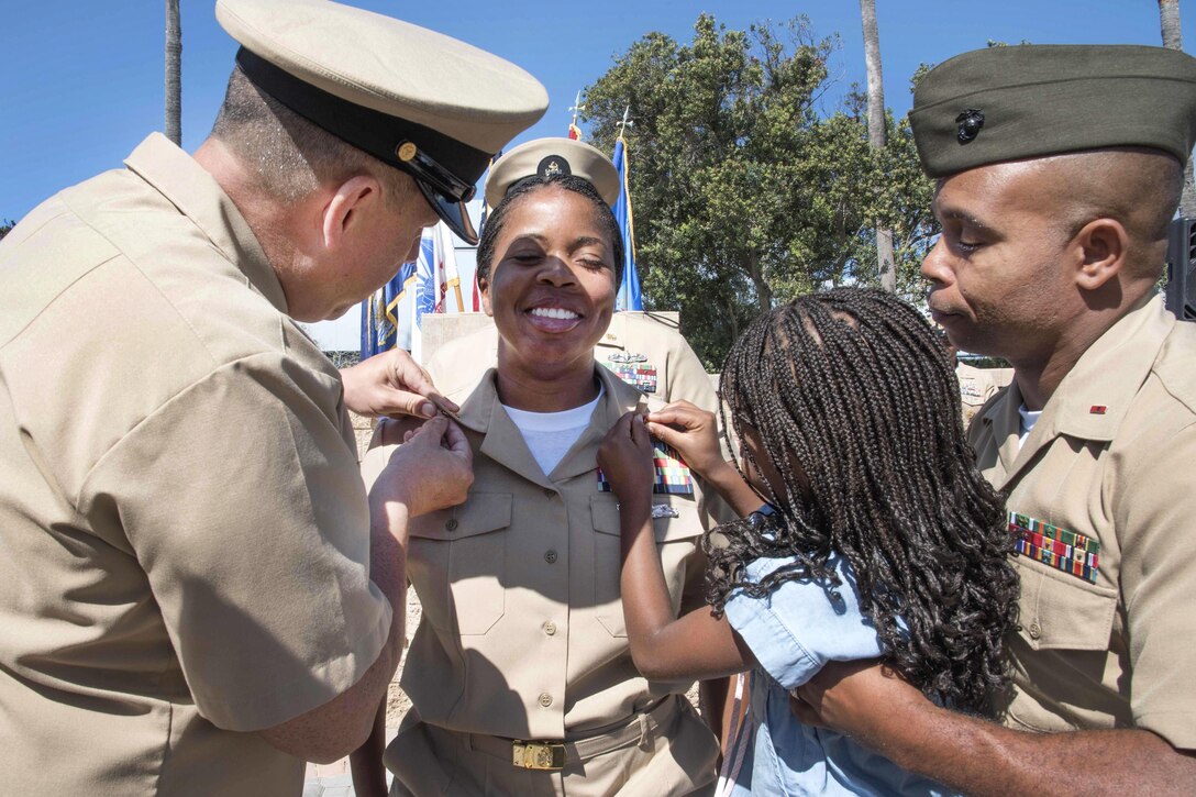 Newly promoted Navy Chief Petty Officer Shana Ard's family pins on her anchors during a chief petty officer pinning ceremony at Commander, U.S. 3rd Fleet headquarters, Point Loma, San Diego, Calif., Sept. 16, 2016. Ard is an information systems technician. Navy photo by Petty Officer 2nd Class Kezia Engrums
