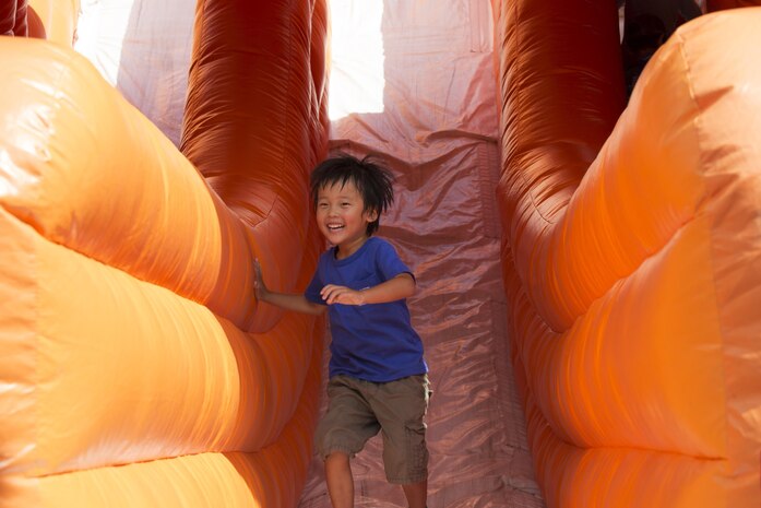 A local child smiles after coming down a slide during the Boys and Girls Club Day for Kids Celebration 2016 at Marine Corps Air Station Iwakuni, Japan, Sept. 17, 2016. The celebration offered bouncy houses, slides and other fun-filled activities for the children who attended. (U.S. Marine Corps photo by Lance Cpl. Joseph Abrego) 