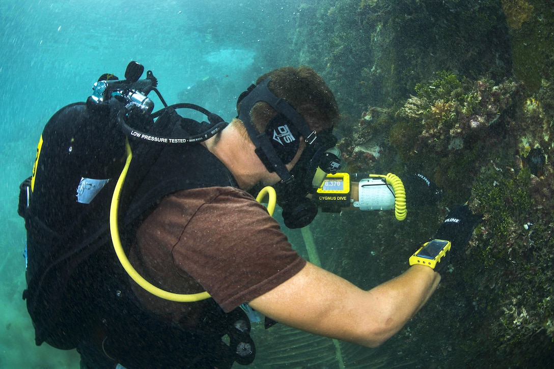 Navy Seaman Lucas Jackson tests the density of metal pylons on a pier during exercise Valiant Shield 2016 in Kwajalein, Marshall Islands, Sept. 16, 2016. Jackson is a construction mechanic constructionman assigned to Underwater Construction Team 2. Navy photo by Petty Officer 2nd Class Daniel Rolston