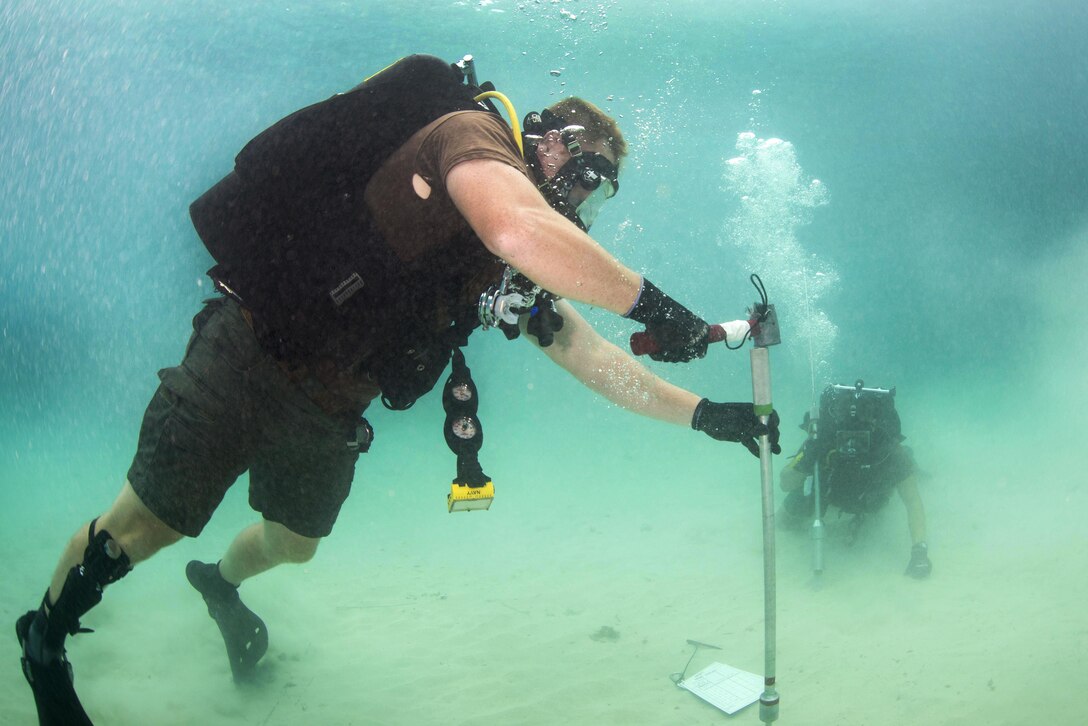 Navy Petty Officer 1st Class David Miller, left, and Navy Seaman Lucas Jackson test the density of the ocean floor during exercise Valiant Shield 2016 in Kwajalein, Marshall Islands, Sept. 16, 2016. Miller is a steelworker and Jackson is a construction mechanic constructionman are assigned to Underwater Construction Team 2. Navy photo by Petty Officer 2nd Class Daniel Rolston 