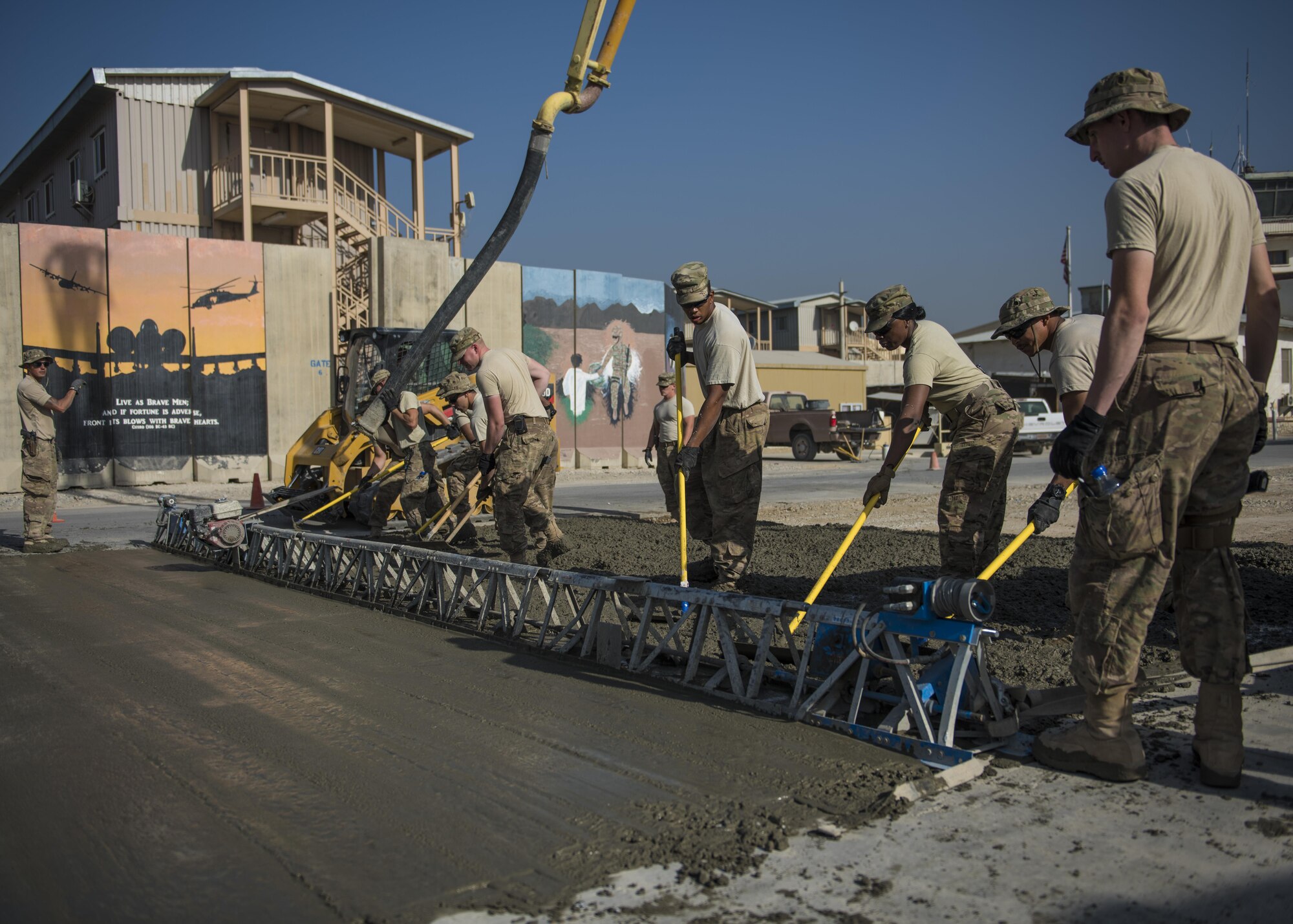 The 455th Expeditionary Civil Engineer Squadron accompanied by volunteers from various base units, level out concrete mixture using an aluminum screed, Bagram Airfield, Afghanistan, Sept. 19, 2016. A screed is used to smooth and vibrate concrete as it is flattened out. (U.S. Air Force photo by Senior Airman Justyn M. Freeman)
