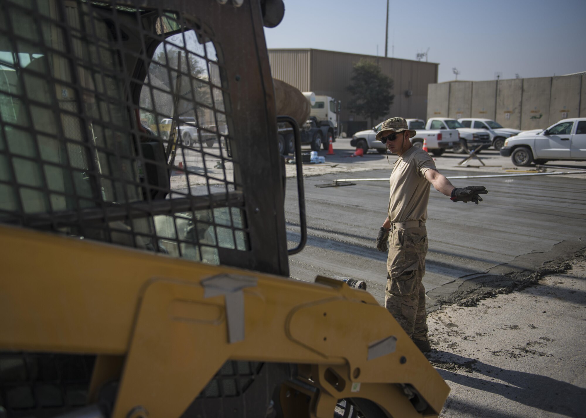 Senior Airman Jacob Nevills, 455th Expeditionary Civil Engineer Squadron pavements and equipment technician, guides a forklift driver during construction, Bagram Airfield, Afghanistan, Sept. 19, 2016. The ECES “dirtboys” placed concrete down in order to extend a parking lot. (U.S. Air Force photo by Senior Airman Justyn M. Freeman)