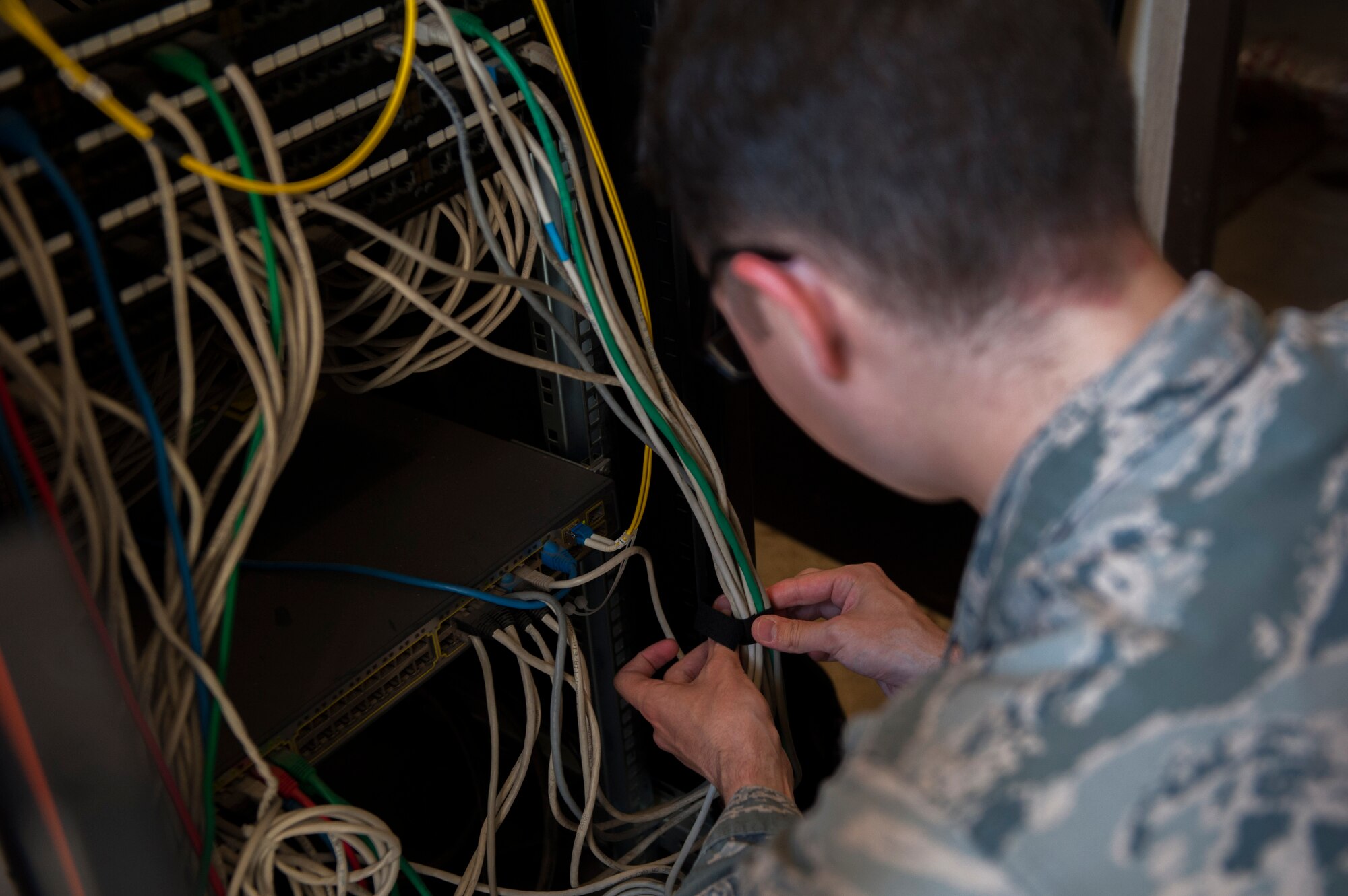 U.S. Air Force Airman 1st Class Nathan Bryant, 39th Communications Squadron cyber transport technician, ties wires together Sept. 19, 2016, at Incirlik Air Base, Turkey. Bryant performed a preventative maintenance inspection to ensure the equipment was organized and compliant with standards. (U.S. Air Force photo by Airman 1st Class Devin M. Rumbaugh)
