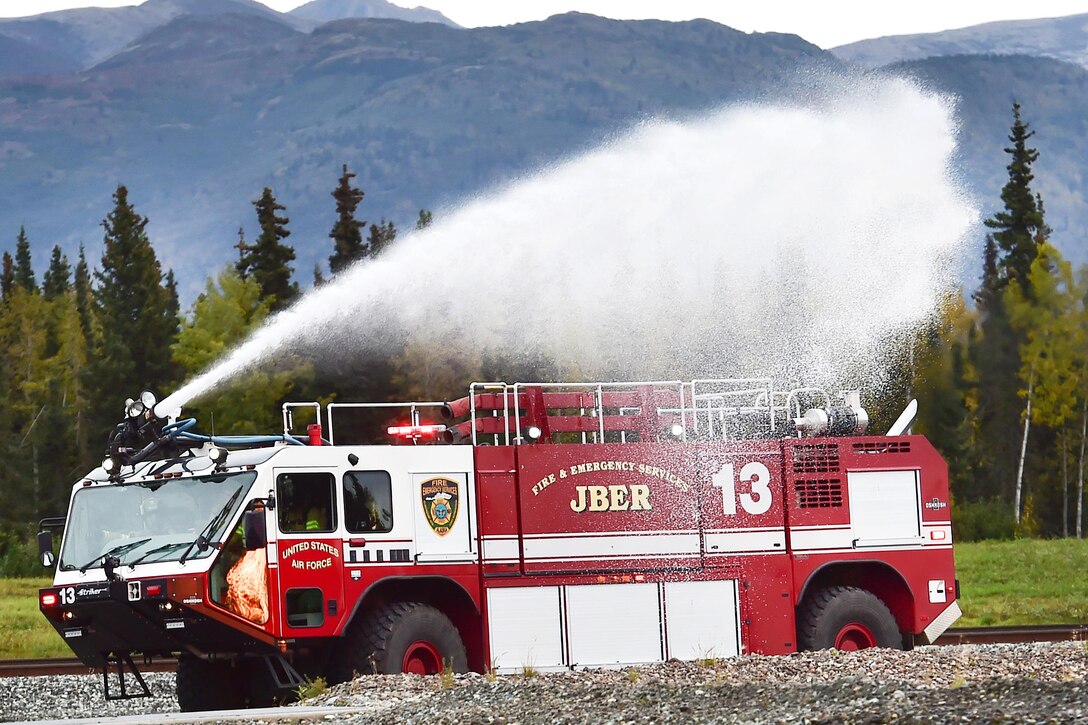 Airmen spray water from a striker vehicle during firefighting training at Joint Base Elmendorf-Richardson, Alaska, Sept. 14, 2016. The airmen, assigned to the 673rd Civil Engineer Squadron, were training to extinguish an aircraft fire. Air Force photo by Justin Connaher  