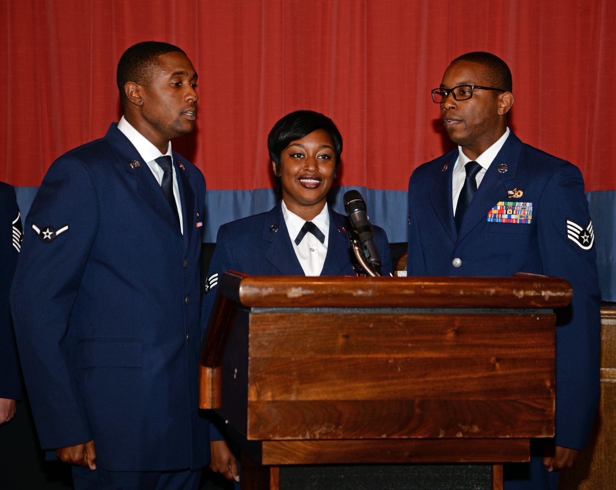 From left to right, U.S. Air Force Airman William Barnes, 352nd Special Operations Aircraft Maintenance Squadron MC-130J Commando II crew chief, Senior Airman Denisha Thomas, 352nd SOAMX communications and navigations systems technician, and Staff Sgt. Ntambwe Kambeya, 100th Logistics Readiness Squadron traffic management supervisor, sing the National Anthem during the opening ceremony of the Air Force Ball Sept. 17, 2016, on RAF Mildenhall, England. The celebration consisted of a presentation of the colors, the playing and singing of the British and American national anthems, social hour, a cake-cutting ceremony, and dancing. (U.S. Air Force photo by Senior Airman Christine Halan)