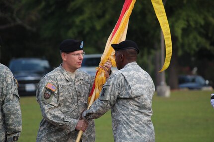Col. Robert A. Wojciechowski, incoming commander of the 207th Regional Support Group hands the guidon to Command Sgt. Maj. Earl E. Lee, command sergeant major of the 207th RSG during the change of command ceremony on Sept. 10. (Official U.S. Army Photo by Spec. Jeff Russo, Unit Public Affairs Representative, 650th Transportation Company, 207th Regional Support Group/Released)