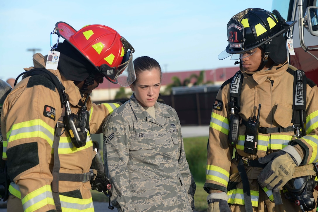 Firefighters from the 6th Civil Engineer Squadron escort Senior Airman Sarah Eby, center, Fuels System Repairman apprentice with the 6th Maintenance Squadron, during an Emergency Management exercise at MacDill Air Force Base, Fla., Sept. 13, 2016. Eby acted as an Airman injured from a vehicle accident during the exercise. (U.S. Air Force photo by Senior Airman Vernon L. Fowler Jr.)