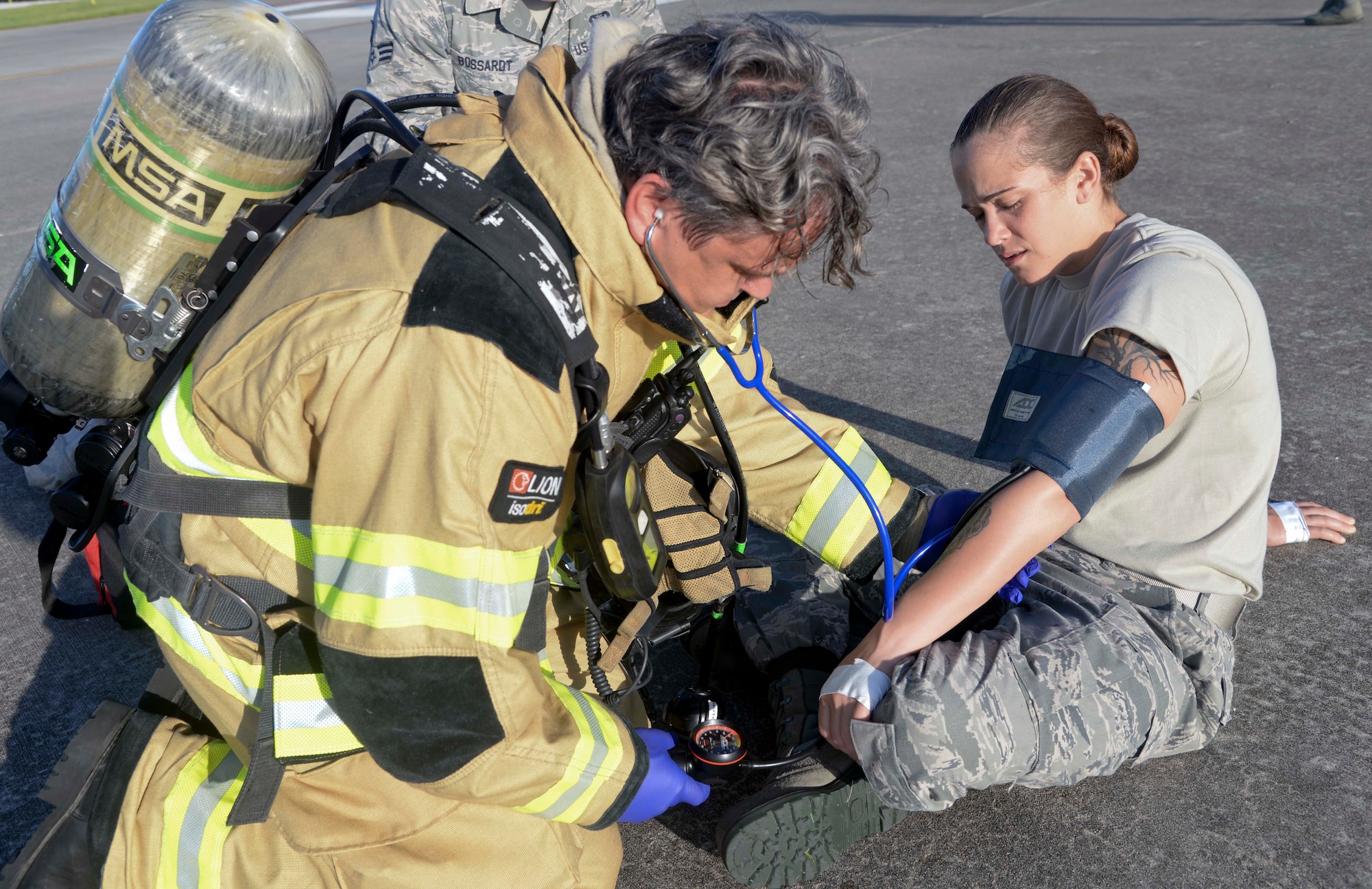 Mr. William R. Stamey Jr., Fire Emergency Services crew chief assigned to the 6th Civil Engineer Squadron, administers medical aid to Senior Airman Sarah Eby, fuels system Repairman apprentice with the 6th Maintenance Squadron, during an Emergency Management exercise at MacDill Air Force Base, Fla., Sept. 13, 2016. Eby was first taken through decontamination before being released for medical treatment. (U.S. Air Force photo by Senior Airman Vernon L. Fowler Jr.)