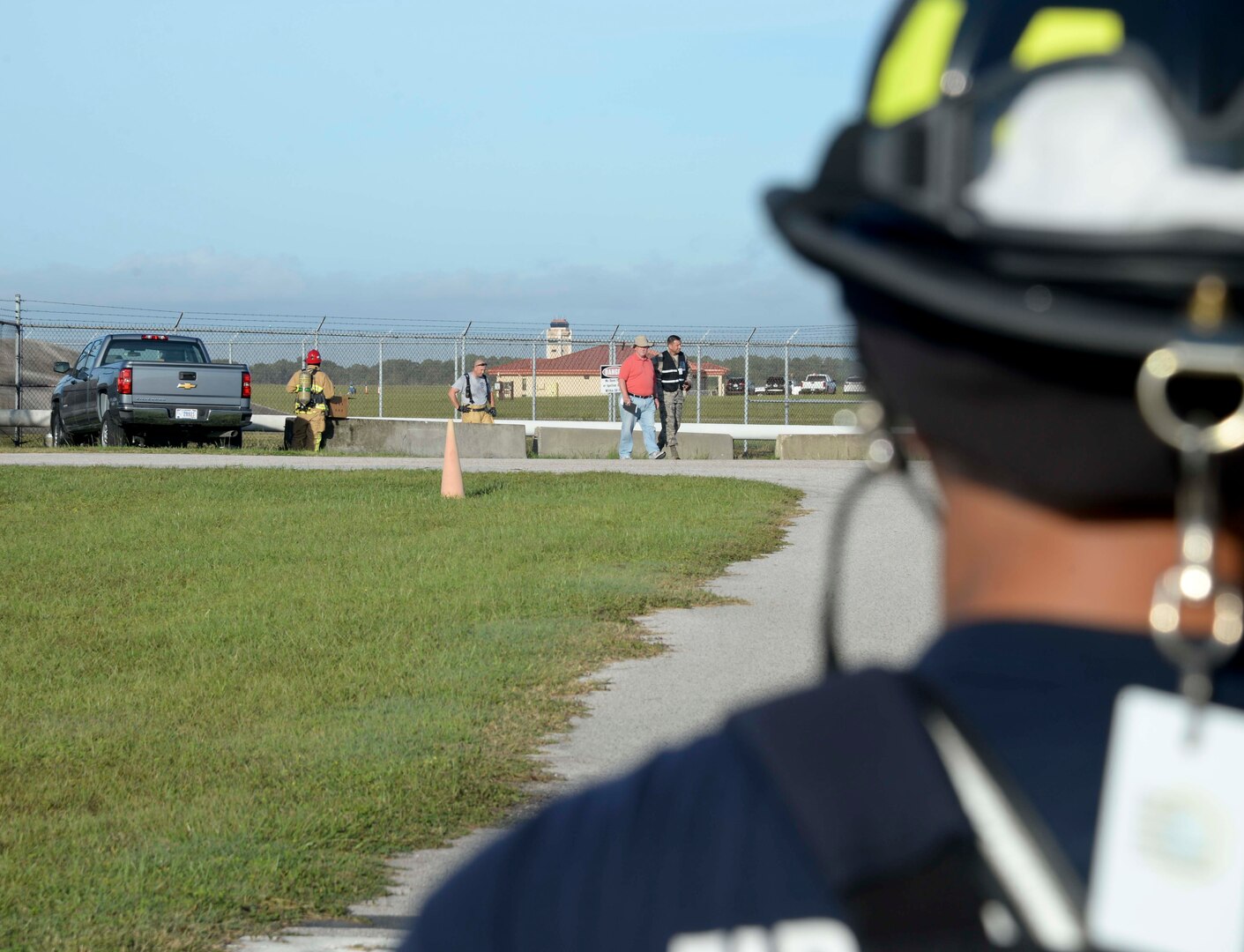 A firefighter from the 6th Civil Engineer Squadron looks on as other firefighters check for environmental damage during an Emergency Management exercise at MacDill Air Force Base, Fla., Sept. 13, 2016. The exercise simulated a fuel spill that resulted from a vehicle accident. (U.S. Air Force photo by Senior Airman Vernon L. Fowler Jr.)