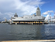 The future USNS Yuma (EPF 8) transits the Mobile river on a launch barge in preparation for its ceremonial launch at Austal USA shipyard, Sept. 16. 