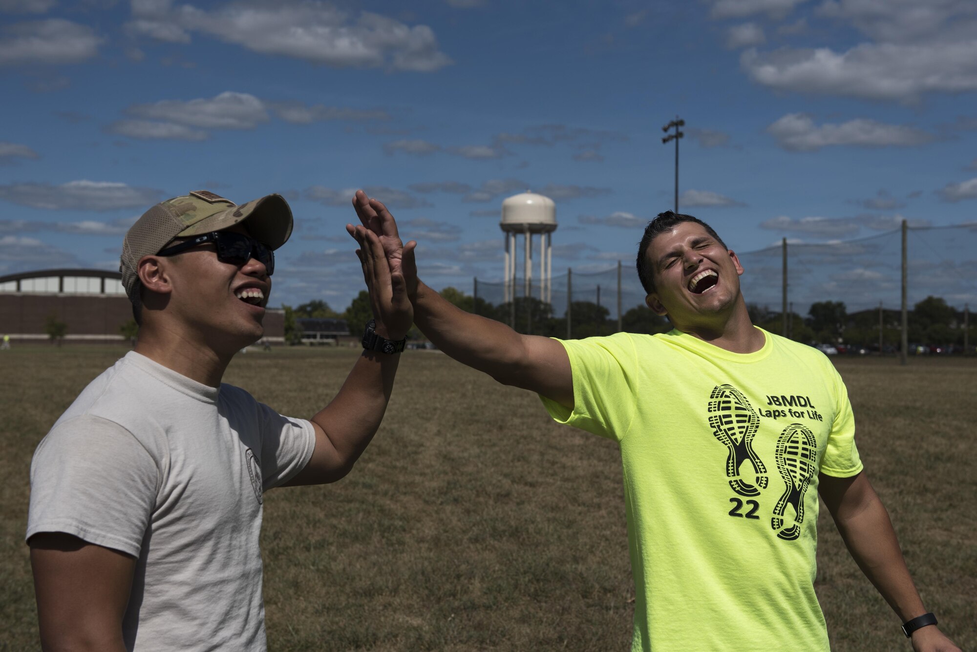 Senior Airman Donald Cosip and Staff Sgt. Richard Babb, 321st Contingency Response Wing aircraft services specialists, celebrate scoring a point in a ring toss game during their break from the Laps for Life event at Joint Base McGuire-Dix-Lakehurst, N.J., Sept. 16, 2016. The 321st CRW had completed over 300 laps by midday in the friendly competition with groups from around the base.