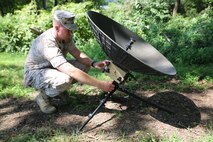 Staff Sgt. Charles McKelvey, Public Affairs Systems program analyst at Marine Corps Systems Command, demonstrates how a Marine can single-handedly setup the new Public Affairs Live Media Engagement System in less than 10 minutes.  PALMES is a lightweight, deployable media system designed to stream live video, conduct interviews with media and upload content via internet.  (U.S. Marine Corps photo by Mathuel Browne)