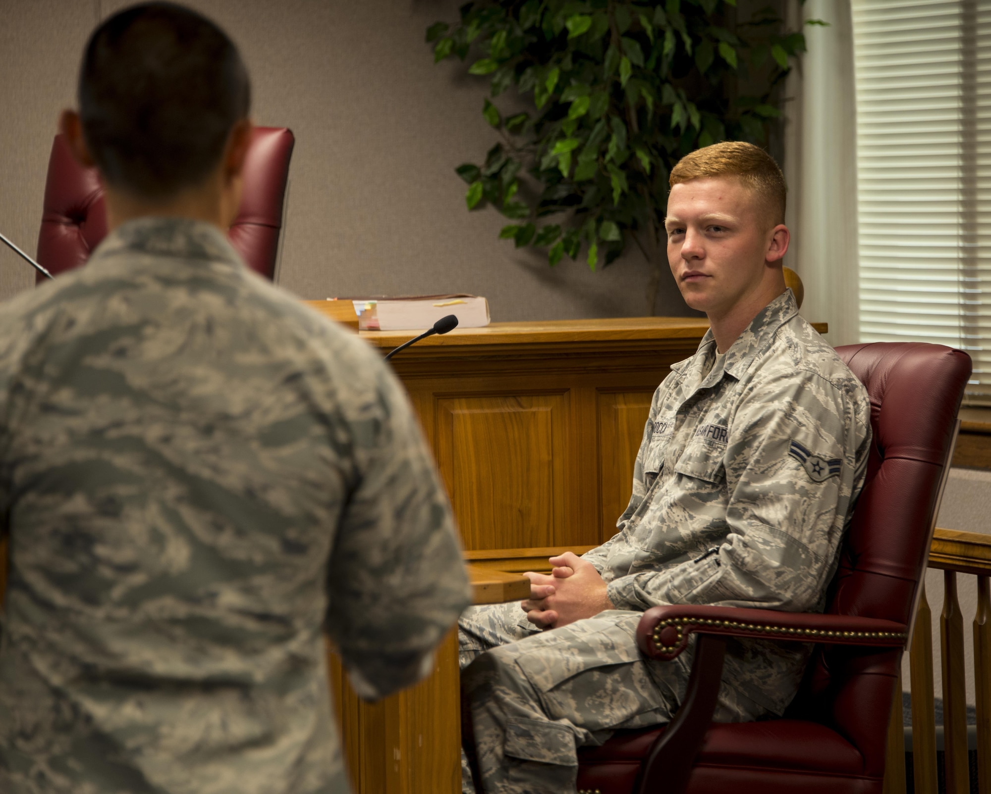 Capt. Joseph Cachuela, 60th Air Mobility Wing Legal Office attorney, left, shows Airman 1st Class Jonathan Rocca, 60th Civil Engineer Squadron electrician, right, what it's like to be on the stand during a court-marital proceeding at Travis Air Force Base, Calif., Sept. 15, 2016. (U.S. Air Force photo by Staff Sgt. Charles Rivezzo)