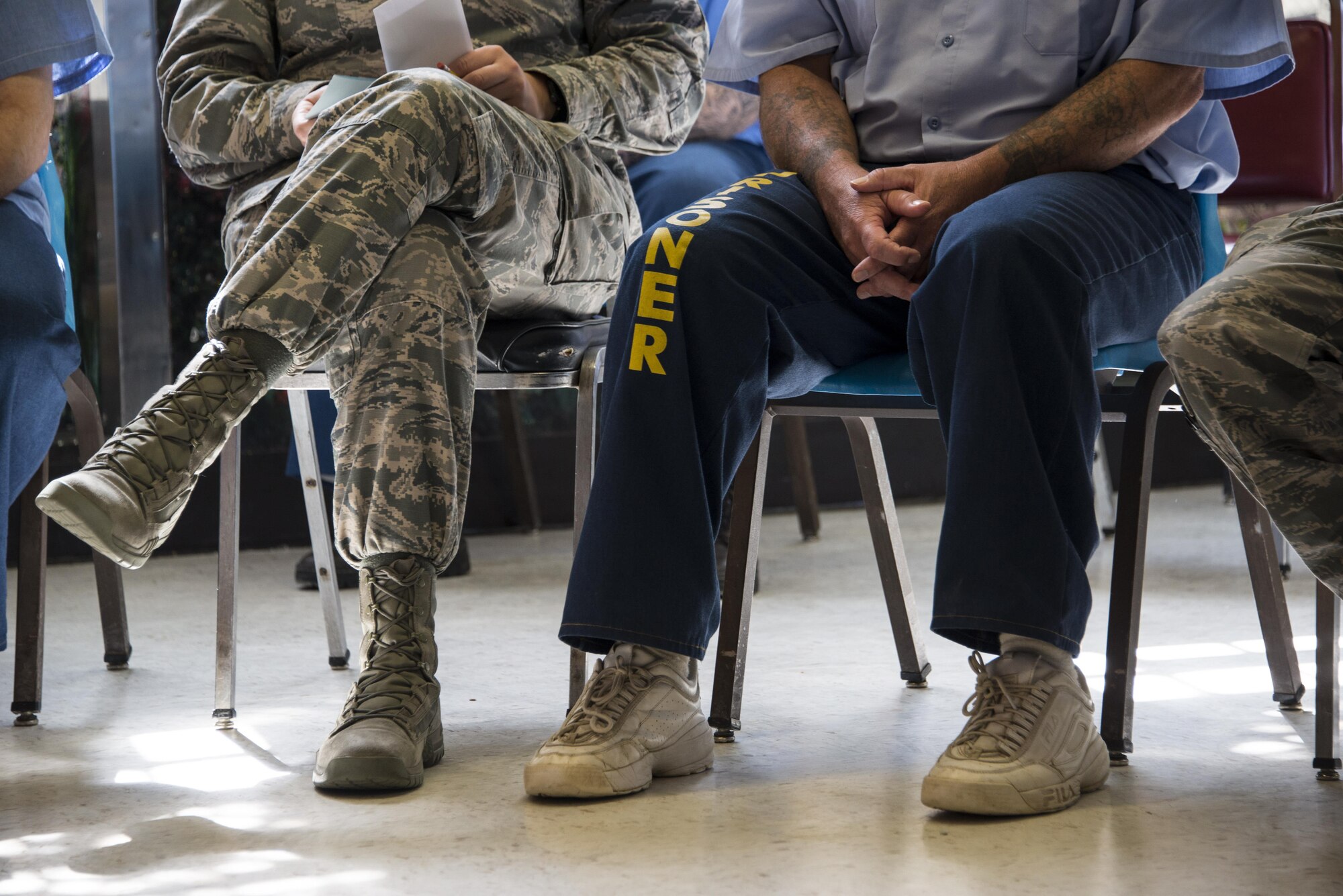 An Airman and inmate sit next to each other and listen to presentations being given by other inmates during the True North program at the California Medical Facility, in Vacaville, Calif., Sept. 15, 2016. As part of the program, Airmen meet with inmates at CMF and hear their personal stories as well as tour the facility. (U.S. Air Force photo by Staff Sgt. Charles Rivezzo) 