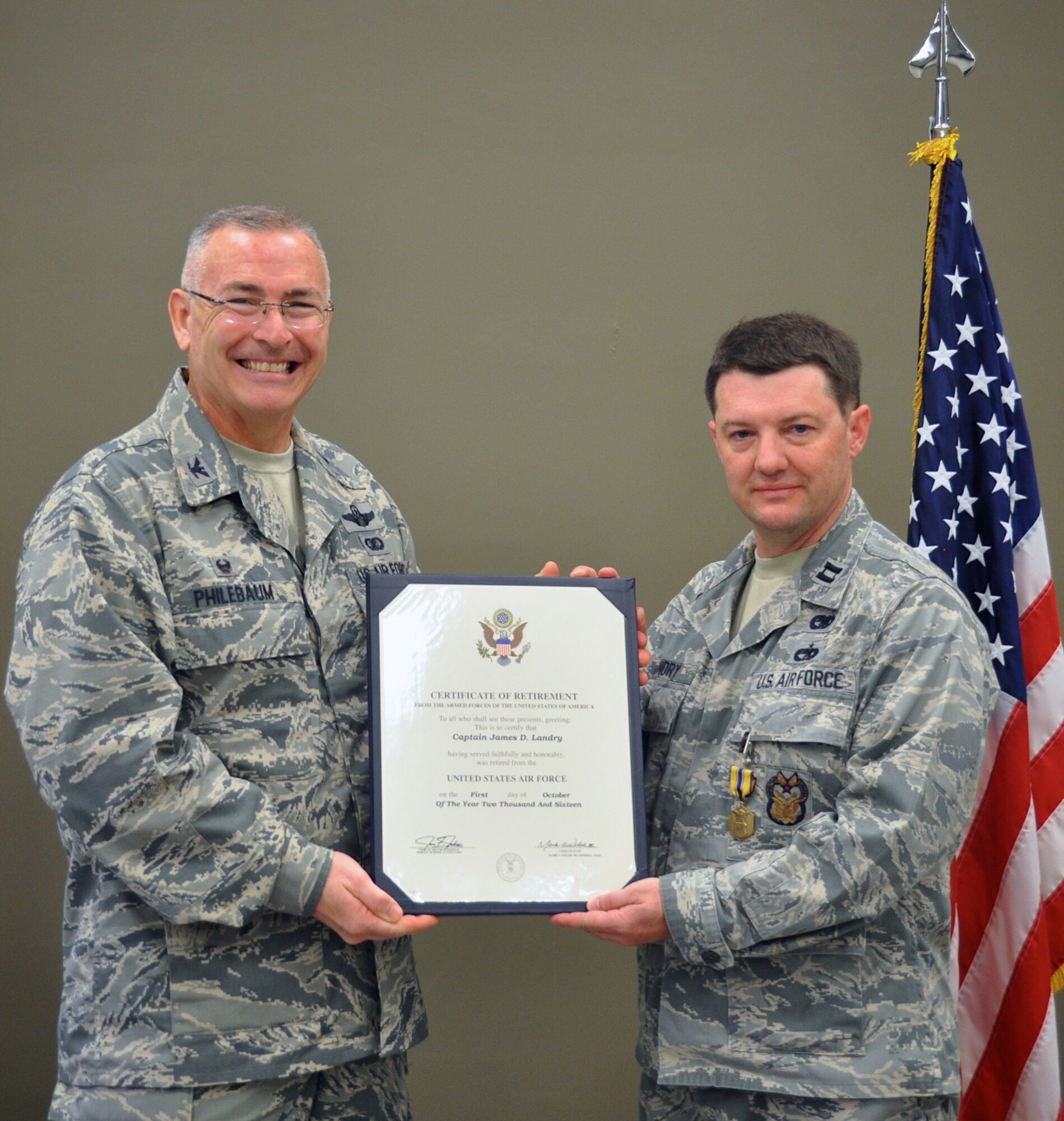 Capt. James Landry, right, and Col. Jonathan Philebaum, left, 932nd Airlift Wing commander, hold Landry's certificate of retirement during his retirement ceremony Sep. 11, 2016, Scott Air Force Base, Illinois.  Landry joined in 1992 and served 23 total years in the Air Force.  He was presented the Air Force Commendation Medal and several tokens of appreciation from co-workers during the ceremony. Landry's final Air Force assignment was with the 932nd AW Inspectors General Office.  (U.S. Air Force photo by Tech. Sgt. Jodi Ames)